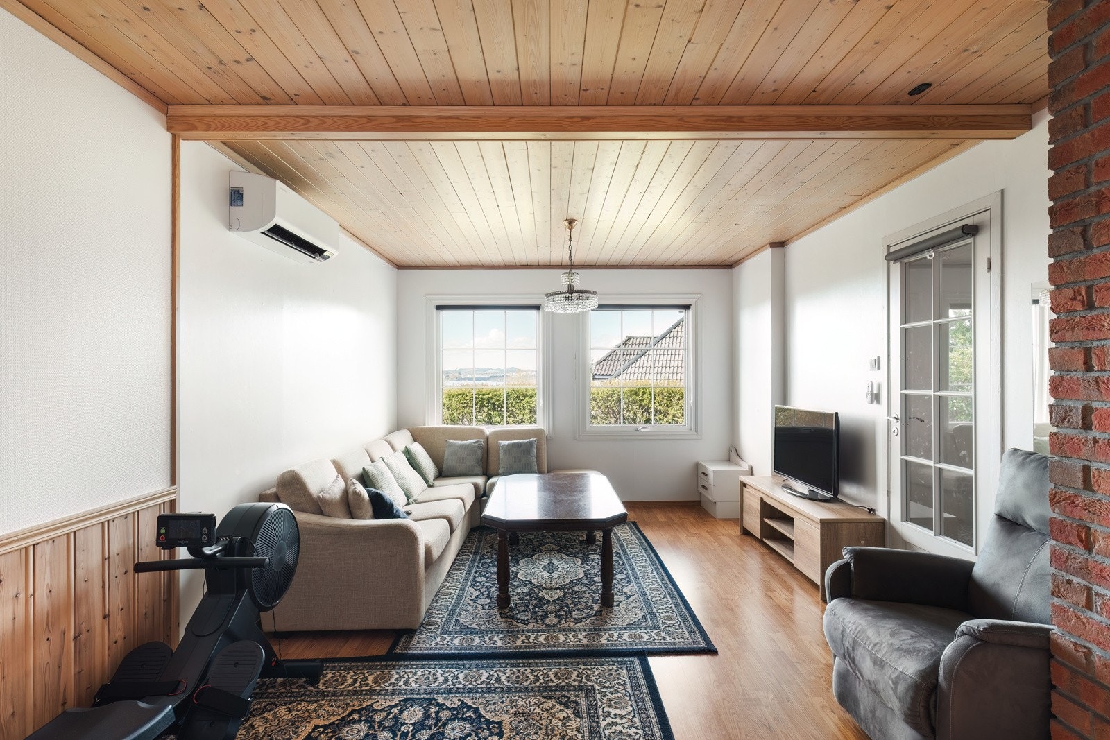 Stor kjellerstue med nyere varmepumpe og vedovn Galleribilde