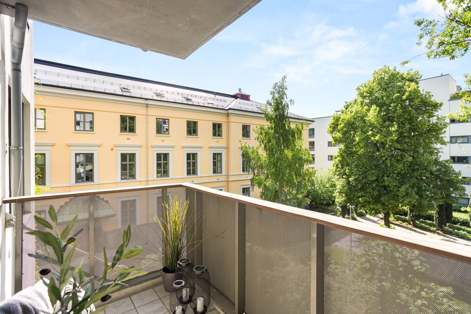 Sydvestvendt balkong fra stue med frodig og flott utsyn mot rolig bakgård og svært gode solforhold. Galleribilde