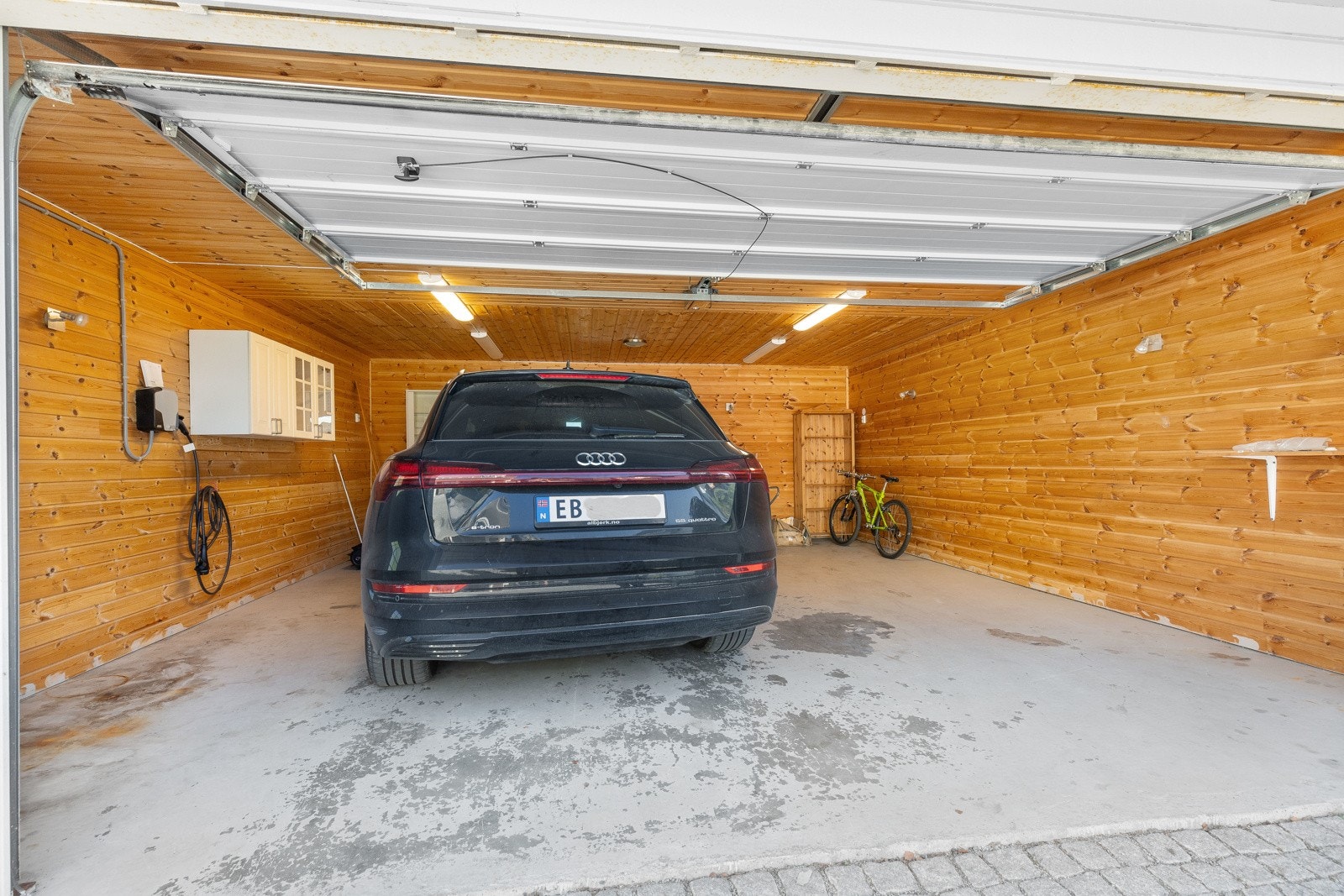 Det er motorisert port og elbillader. Galleribilde
