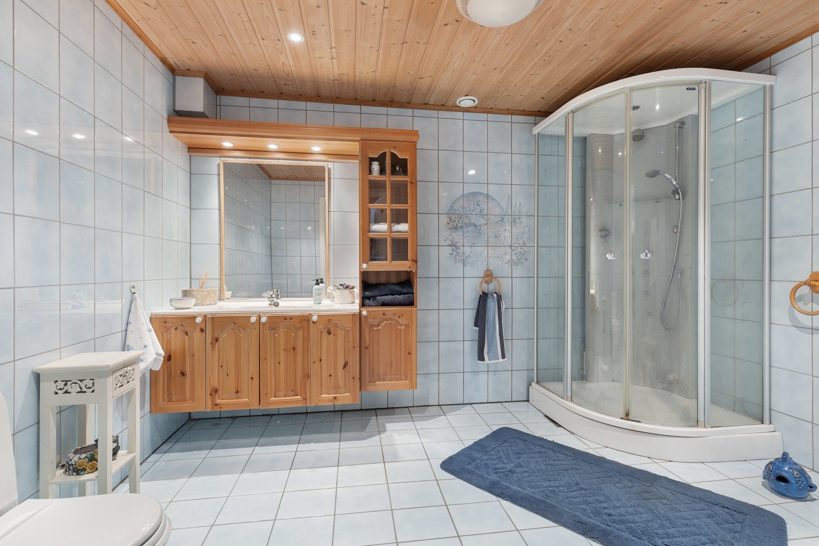 Badet i underetasjen har flislagte overflater, innfelte spotter i himlingen og naturlig avtrekk. Galleribilde