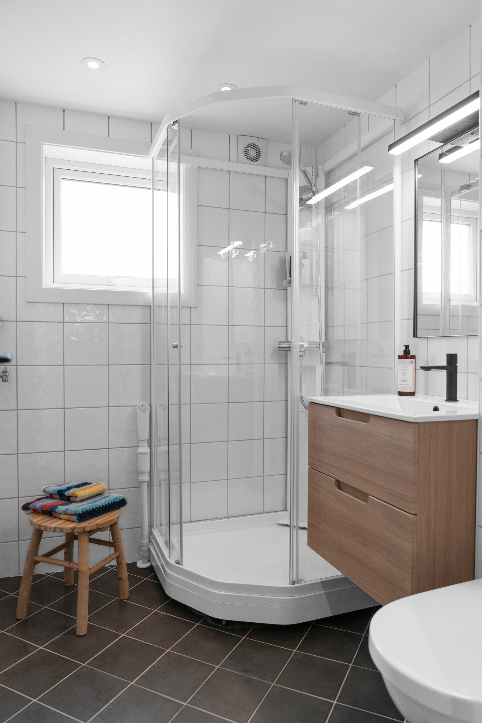 Badet er innredet med dusjkabinett, baderomsinnredning med servant, toalett og opplegg for vaskemaskin. Galleribilde