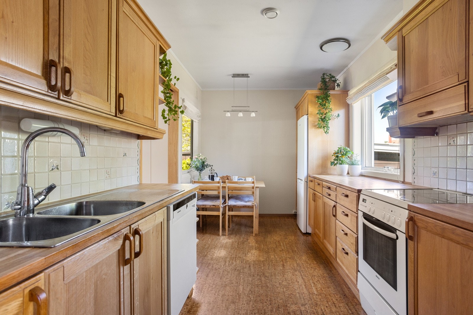 Innredningen har profilerte heltrefronter, åpne hyller og solid heltrebenkeplate med nedfelt kum i stål Galleribilde