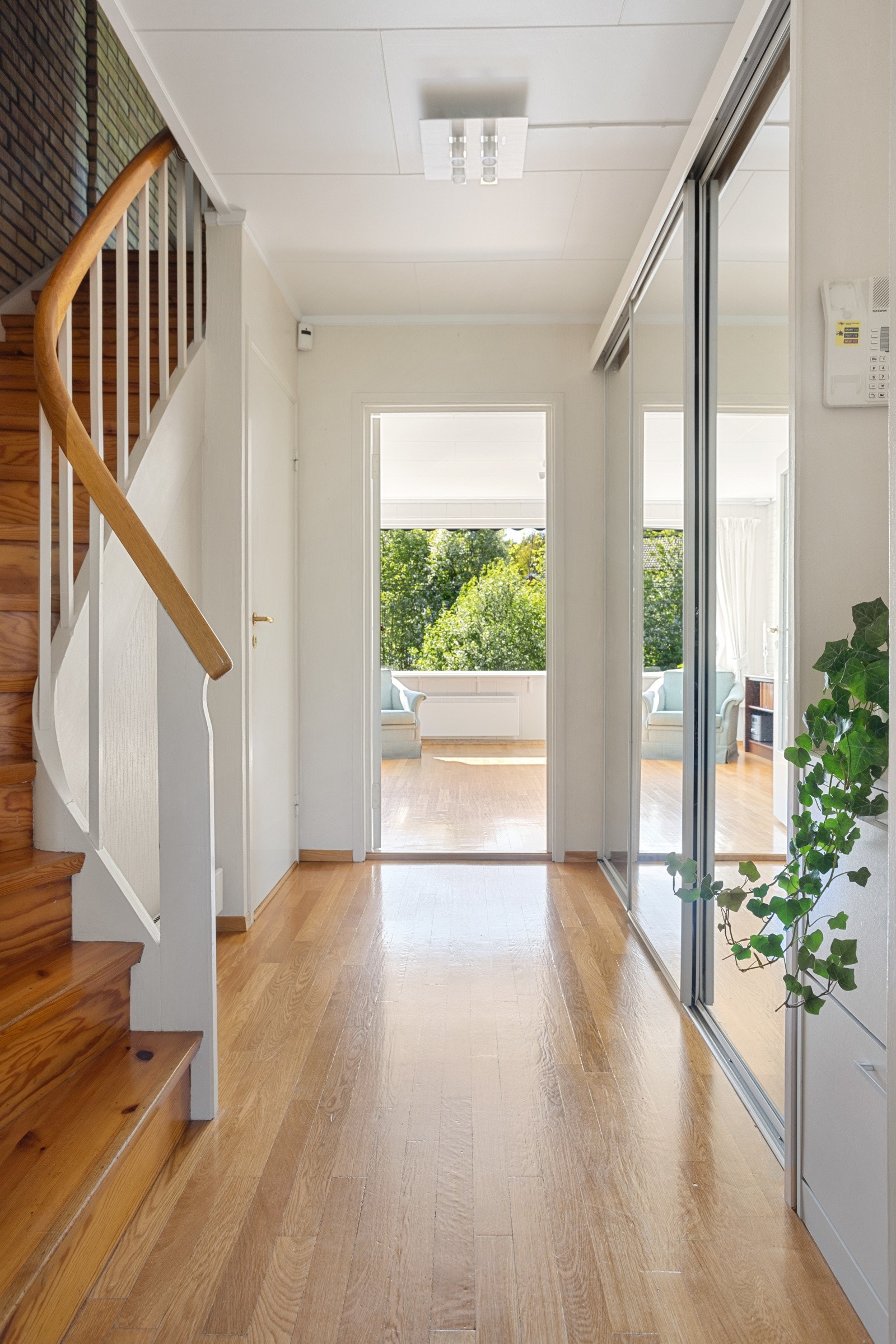 Entréen har en tilliggende garderobe, og i trappegangen innenfor er det en stor, plassbygd skyvedørsgarderobe Galleribilde