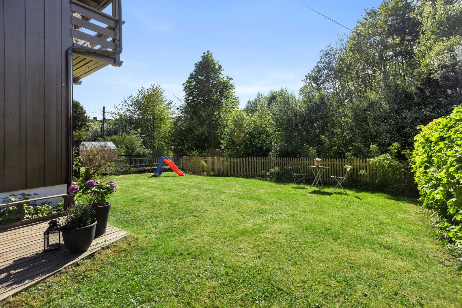 Mot vest er det en stor, solrik hage hvor familiens minste kan boltre seg i trygge omgivelser Galleribilde