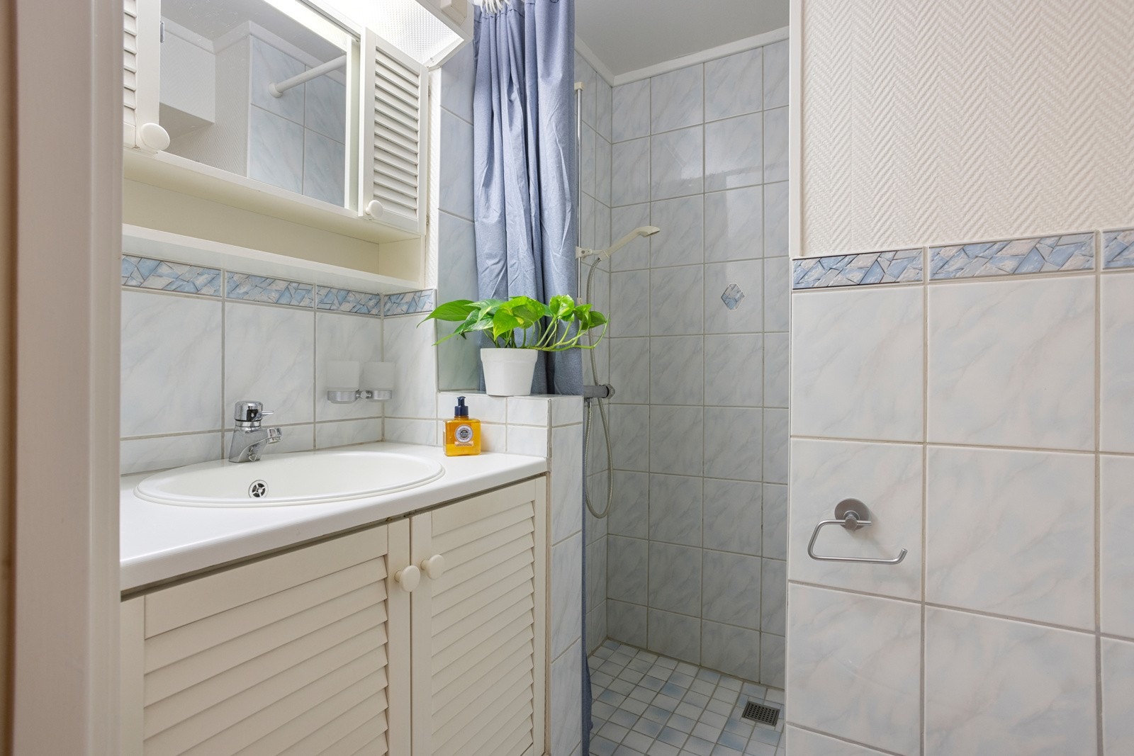 Badet i kjelleren har gulvvarme, toalett, dusjnisje, nedfelt servant i en skapseksjon og et speilskap med belysning Galleribilde