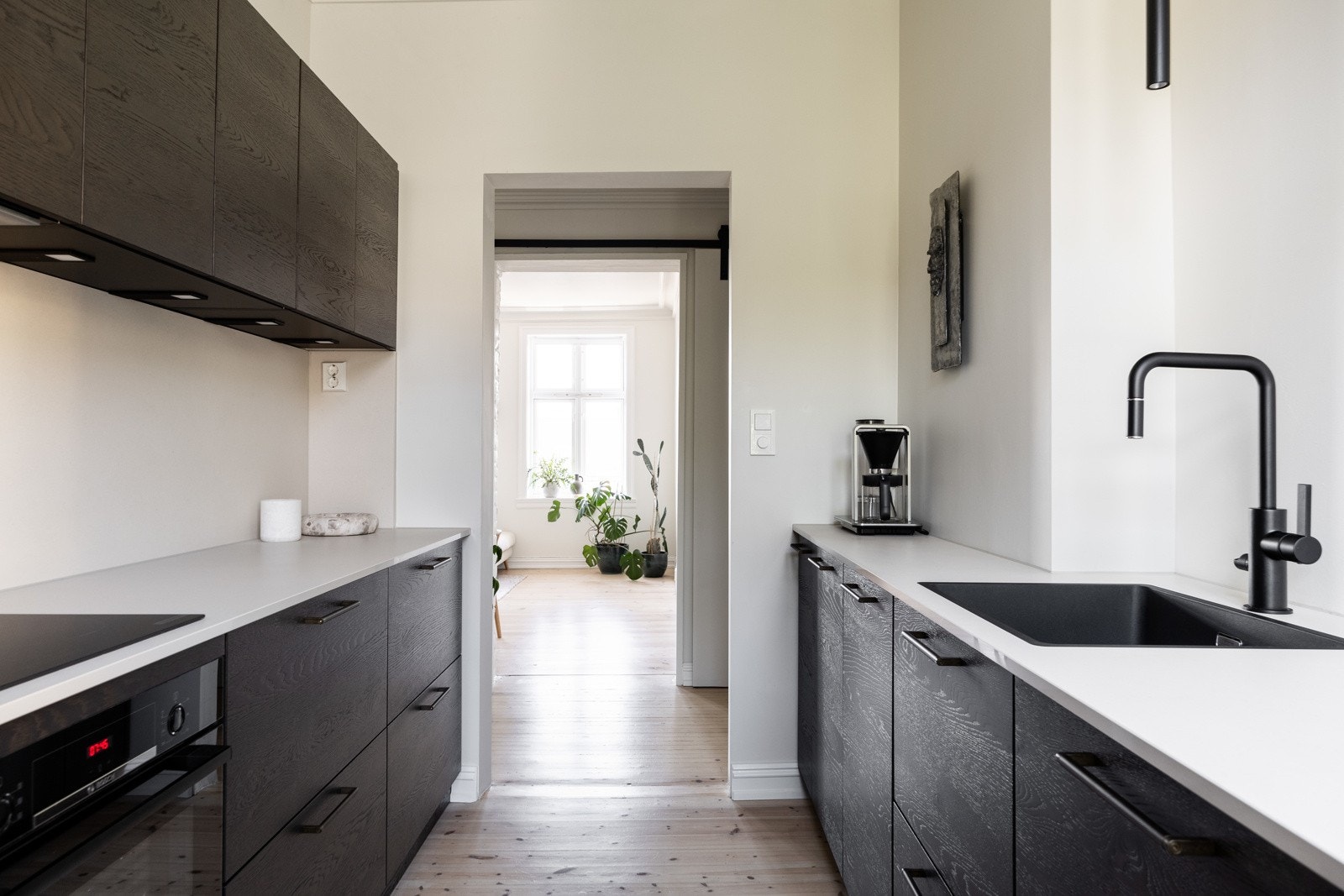 Integrerte hvitevarer består av stekeovn, oppvaskmaskin og kjøleskap med frysedel. Det er induksjonstopp i benkeplate og ventilator med belysning og kullfilter. Galleribilde