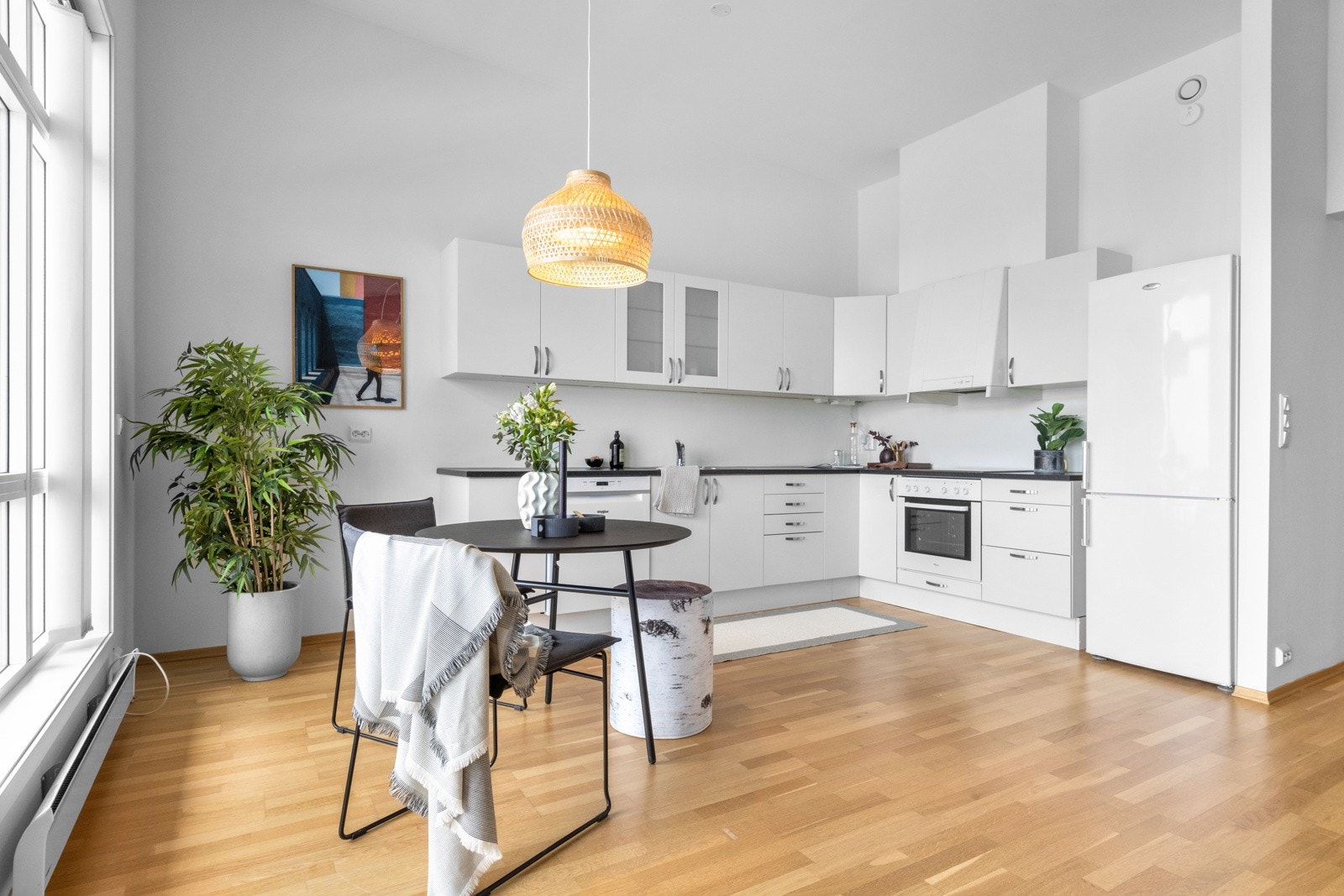 Hvit kjøkkeninnredning med slette fronter og integrert stekeovn og platetopp. Galleribilde