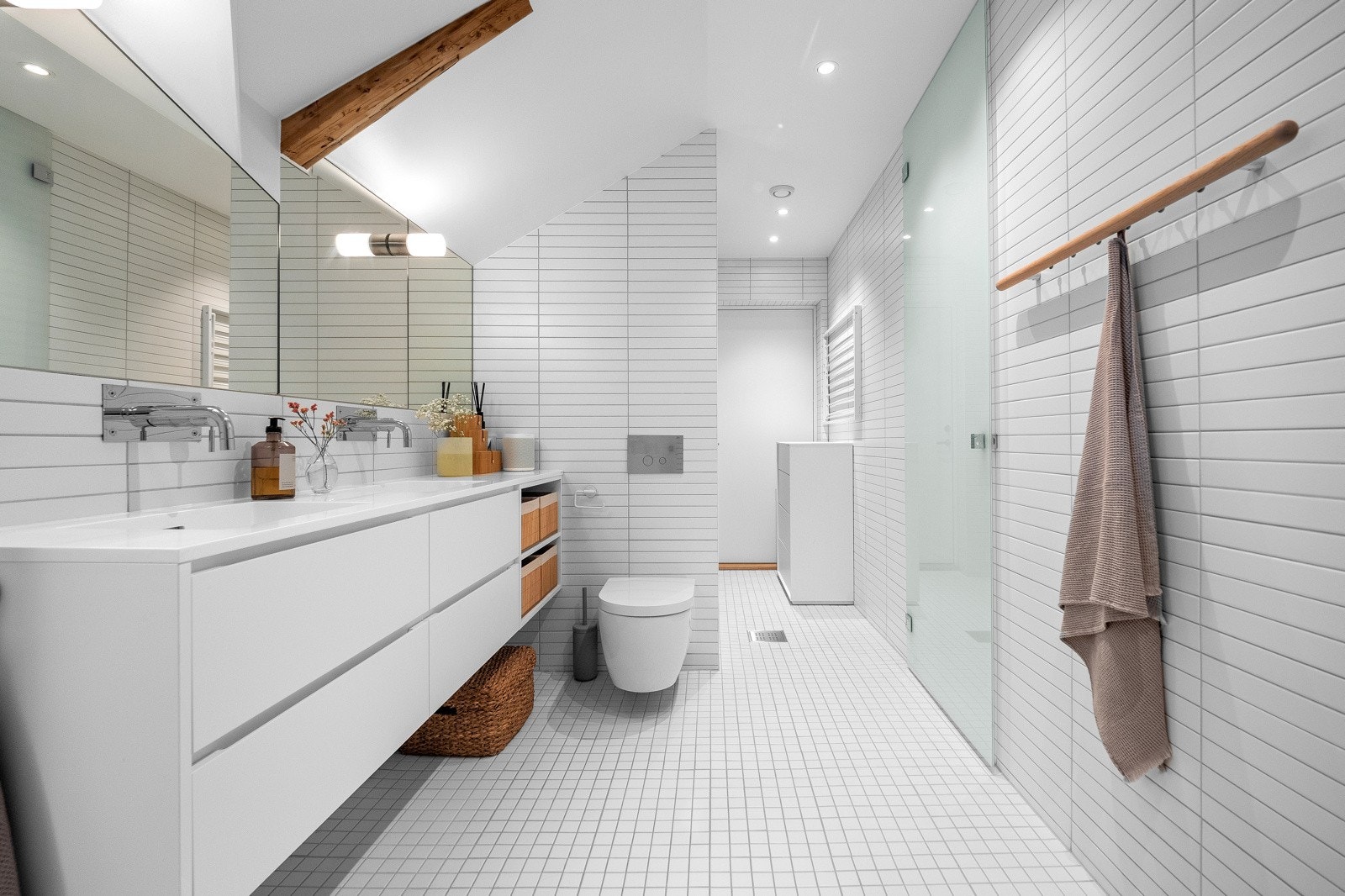 Badet er utstyrt med vegghengt toalett, servant, fliser på gulv og vegger og plassbygget tørkestativ. Galleribilde
