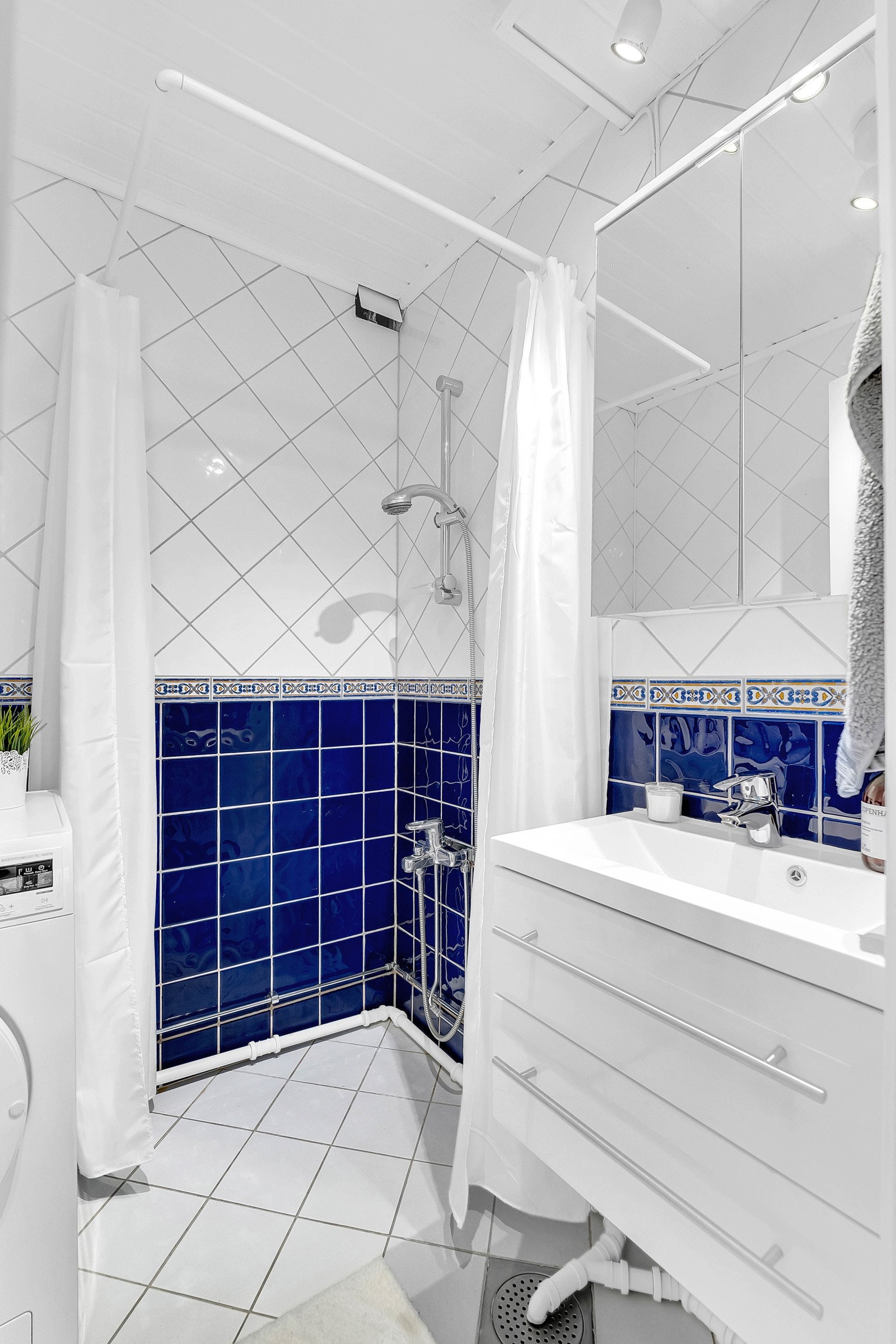 Badet har dusjløsning, varmekabel i gulvet og opplegg for vaskemaskin. Galleribilde