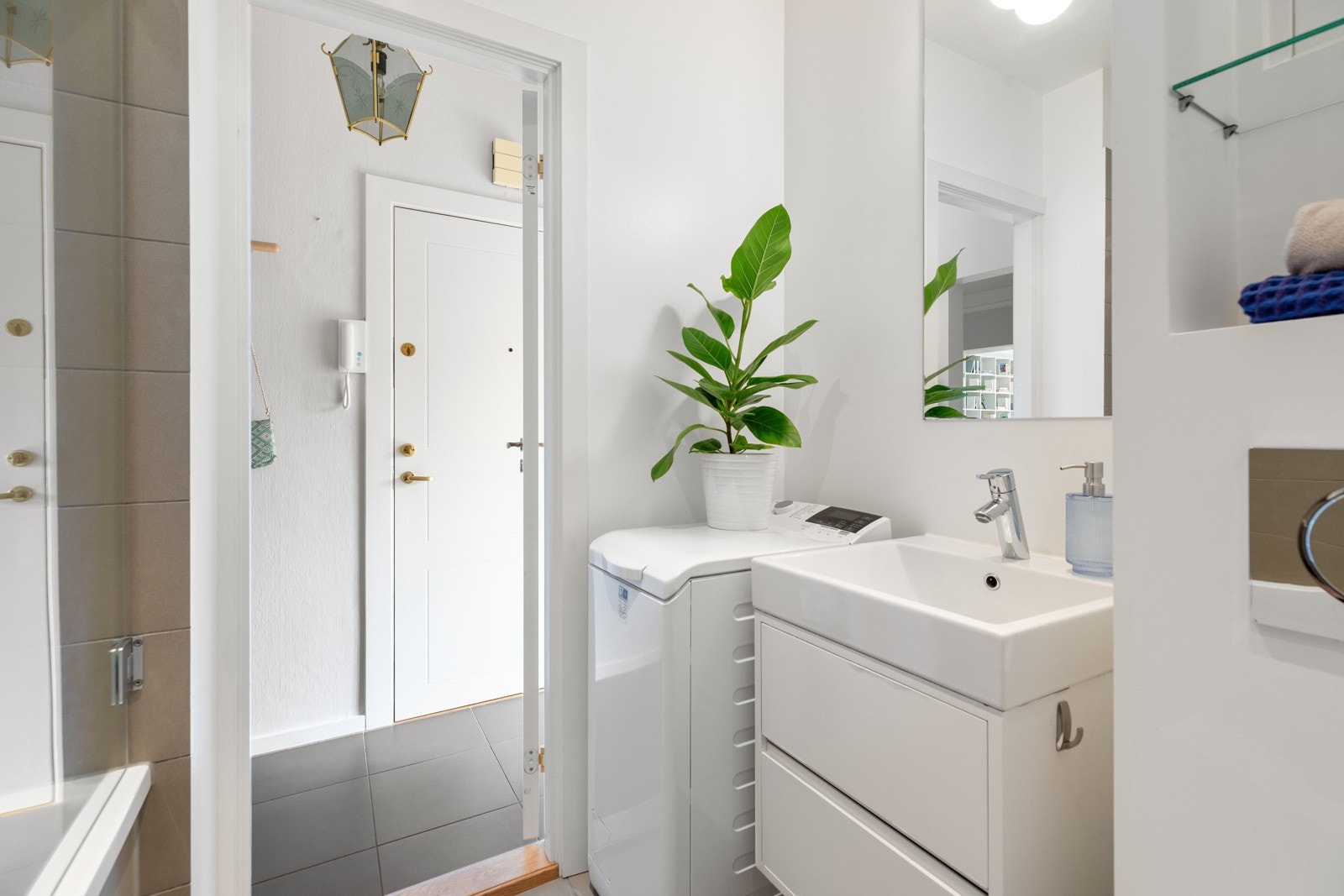 Delvis flislagt bad med varmekabler, innmurt badekar og opplegg for vaskemaskin Galleribilde