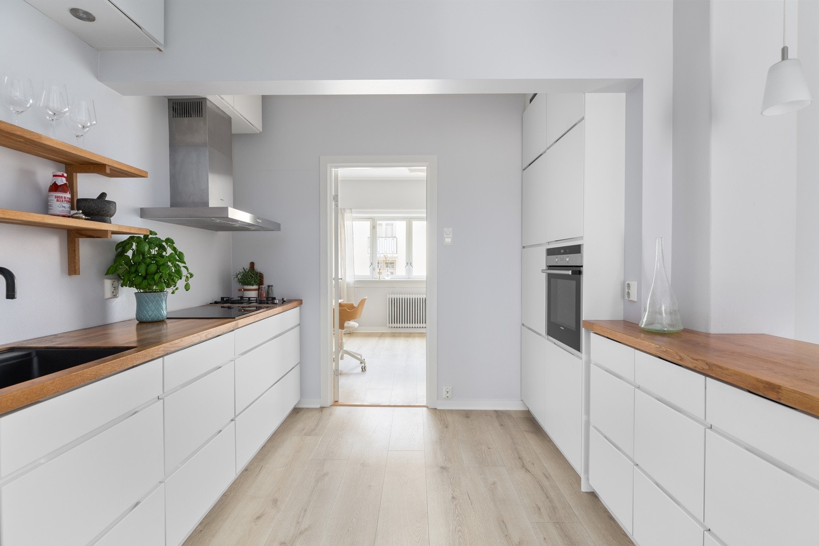 Praktisk og funksjonelt kjøkken med innredning på to sider Galleribilde