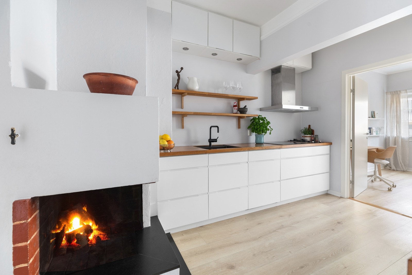 Kjøkkeninnredning fra HTH med hvite greps frie fronter og innredning på to vegger Galleribilde