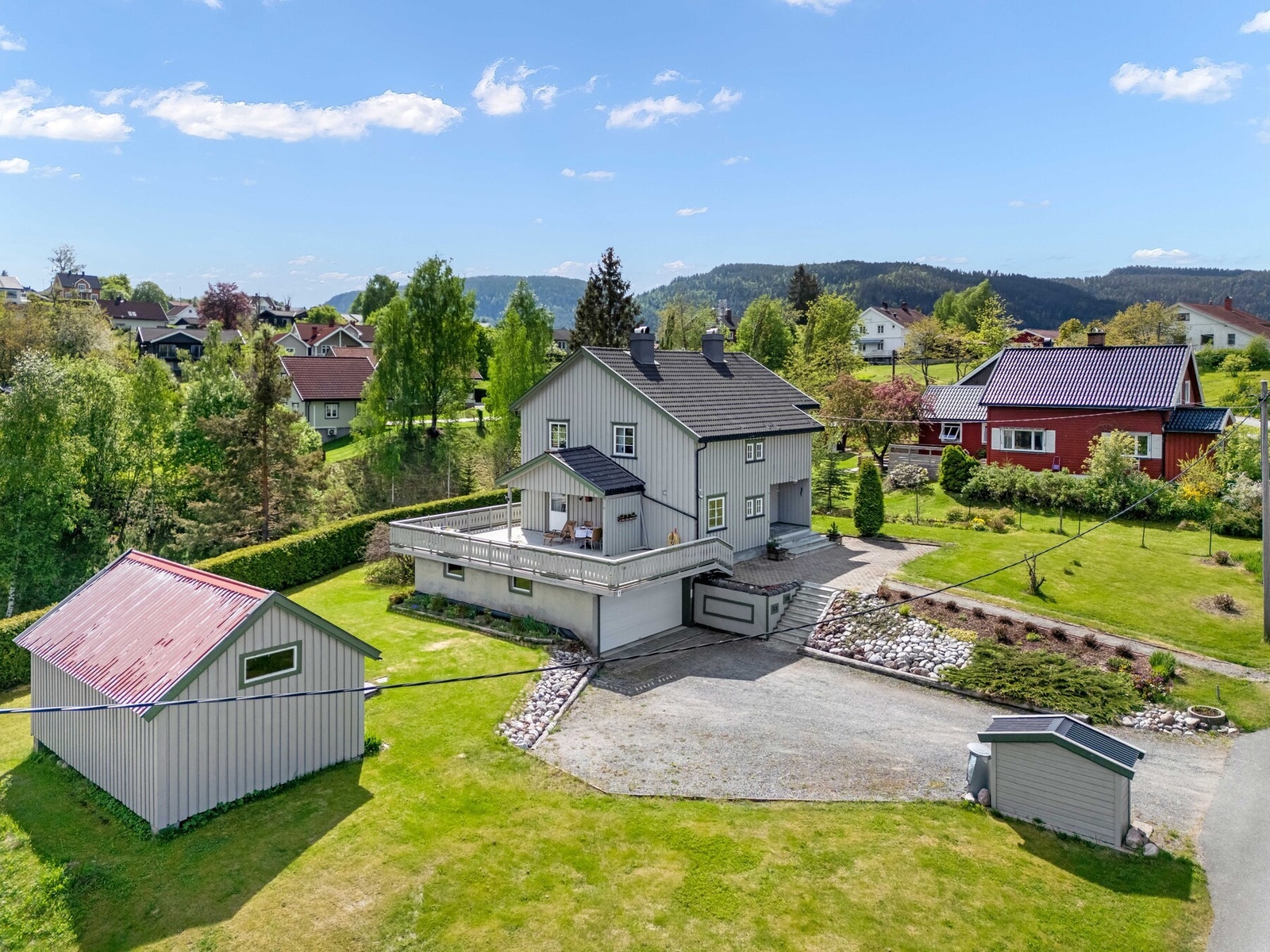 Stor integrert garasje under terrassen og en praktisk bod/redskapshus i hagen. Galleribilde
