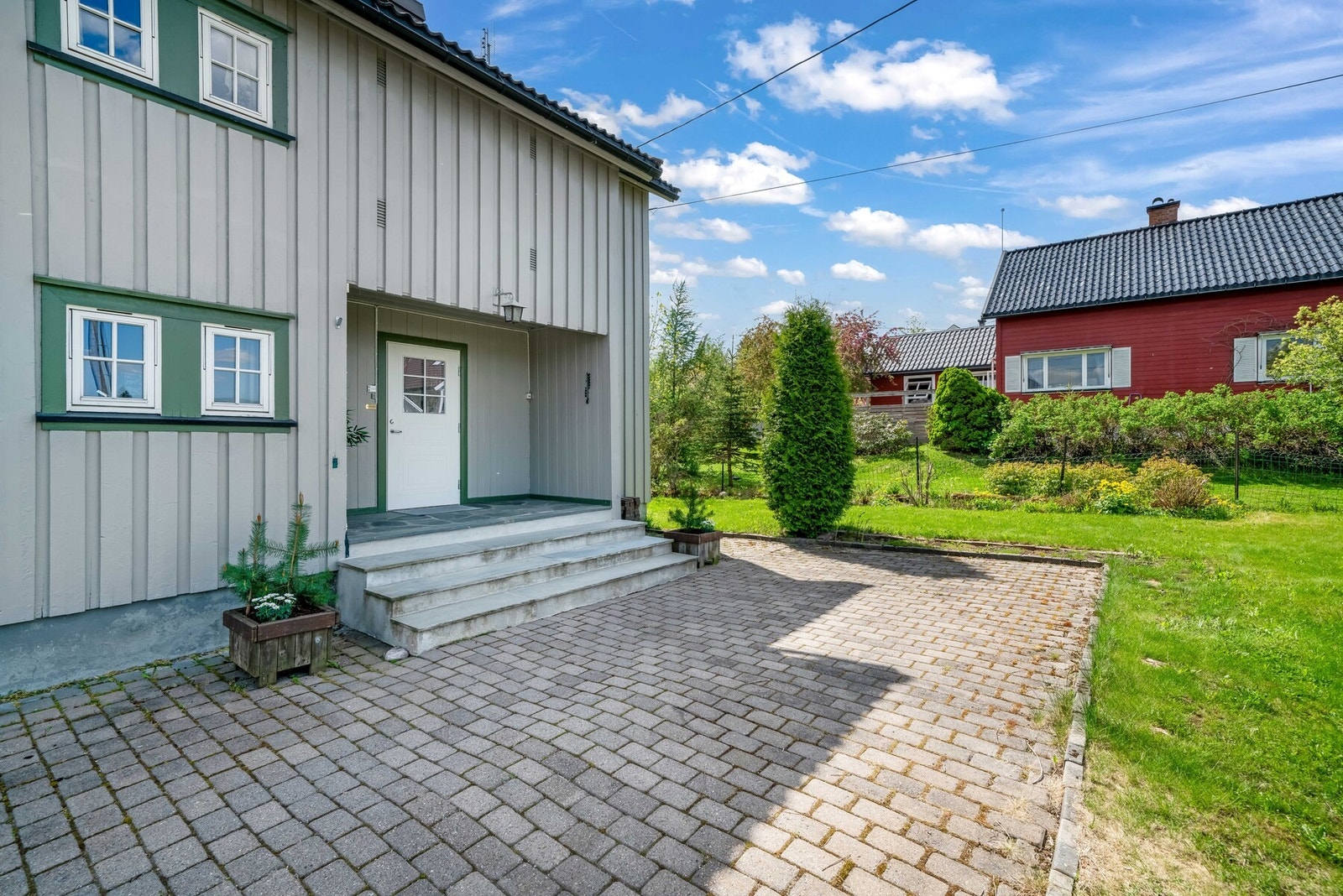 Inngangspartiet er overbygget og har skiferfliser på trappen. Belegningsstein ved inngangen. Galleribilde