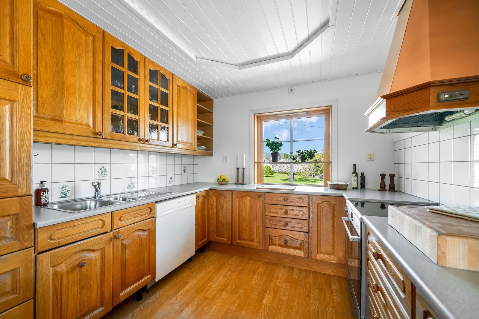 Lunt, lyst og tidløst U-formet eikekjøkken med morgensol. Kjøkkenet har god skap- og benkeplass. Galleribilde