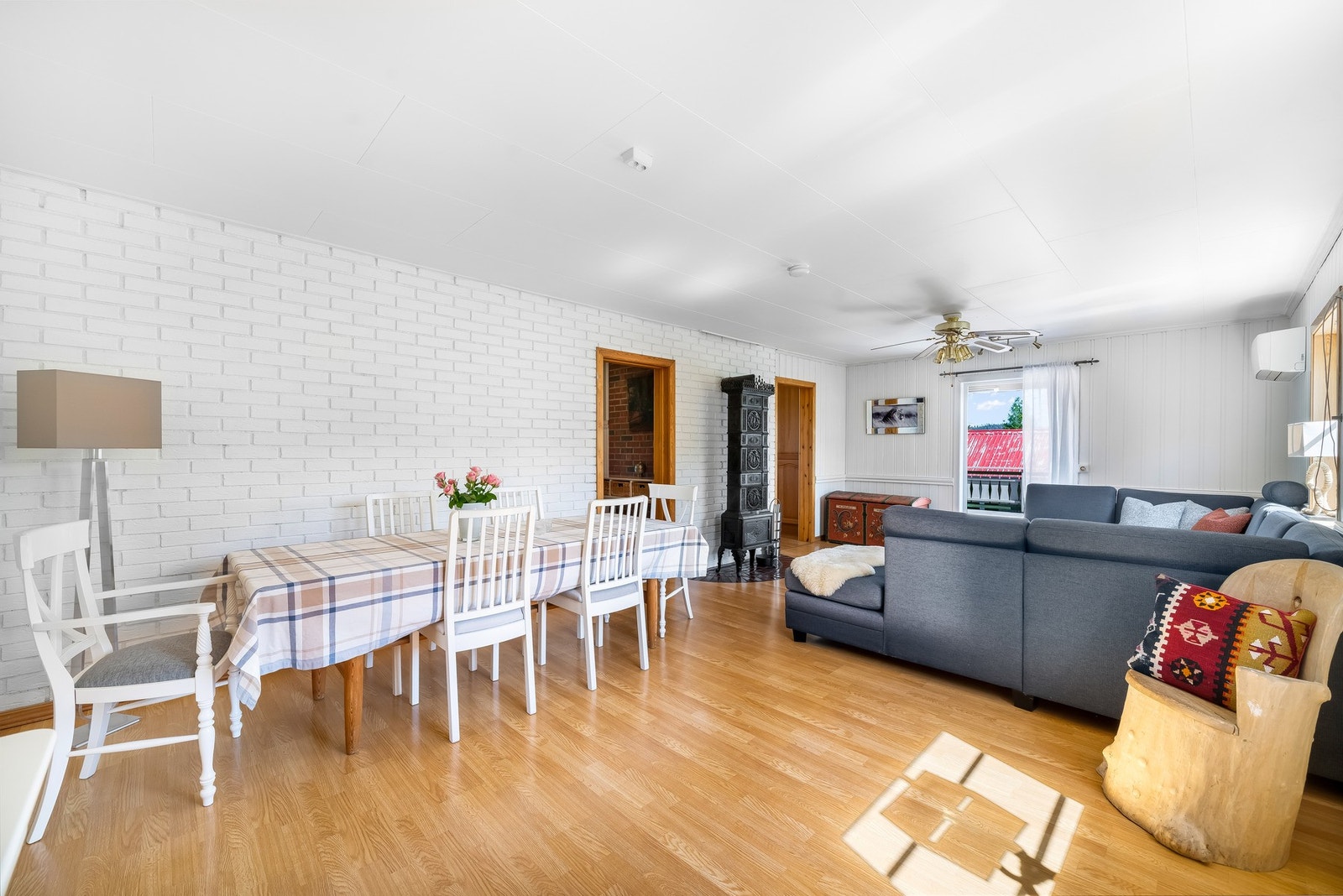 I stuen er det også god plass til spisestue. Hvitmalt teglsteinsmur i bakgrunn. Galleribilde