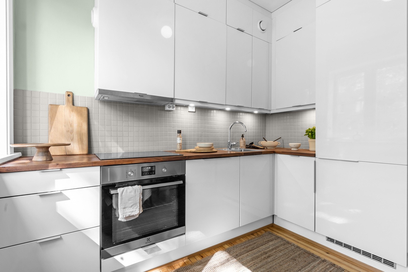 Kjøkkenet er utstyrt med glatt kjøkkeninnredning, heltre benkeplate, fliser over benk, utslagsvask med ett-greps blandebatteri, kjøkkenventilator og opplegg for oppvaskmaskin. Galleribilde