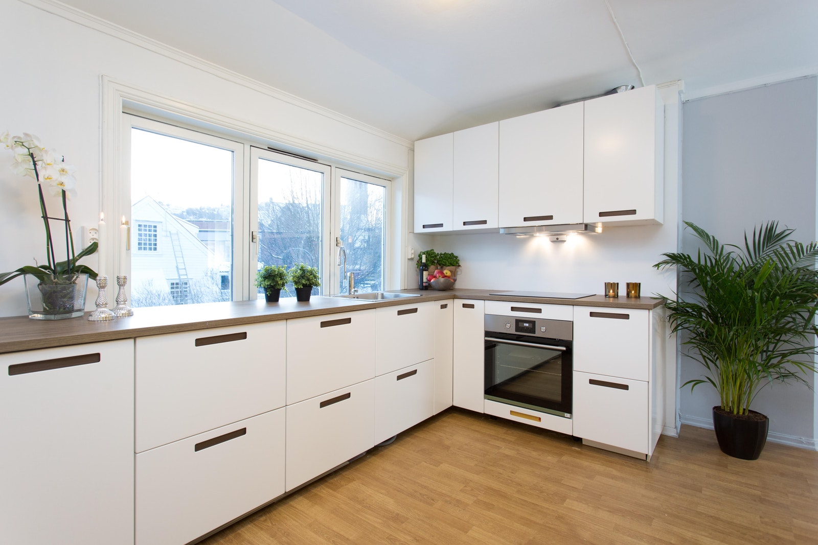 Fresht og moderne kjøkken med spisebord og utsikt mot hage Galleribilde