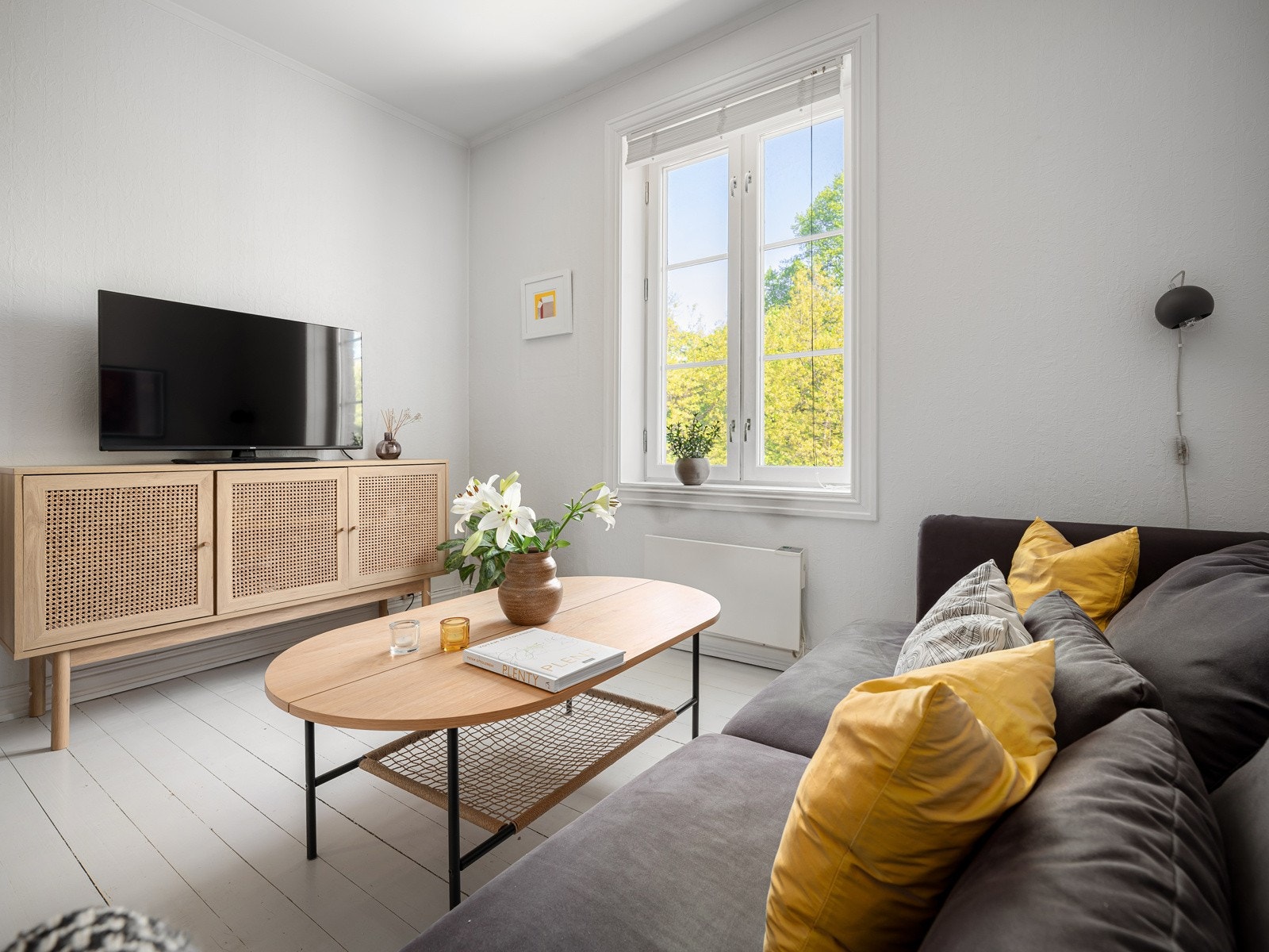 Veggene i stuen har hvitmalt tapet og originale tregulv. Galleribilde