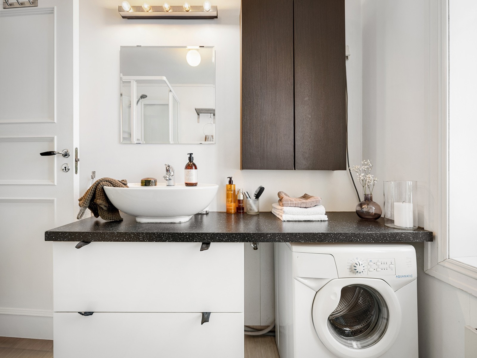 Baderommet består av ovenpåliggende servant med benkeplate og underskap (2006), speil med overlys, skapløsning, dusjkabinett og toalett (2022). Galleribilde