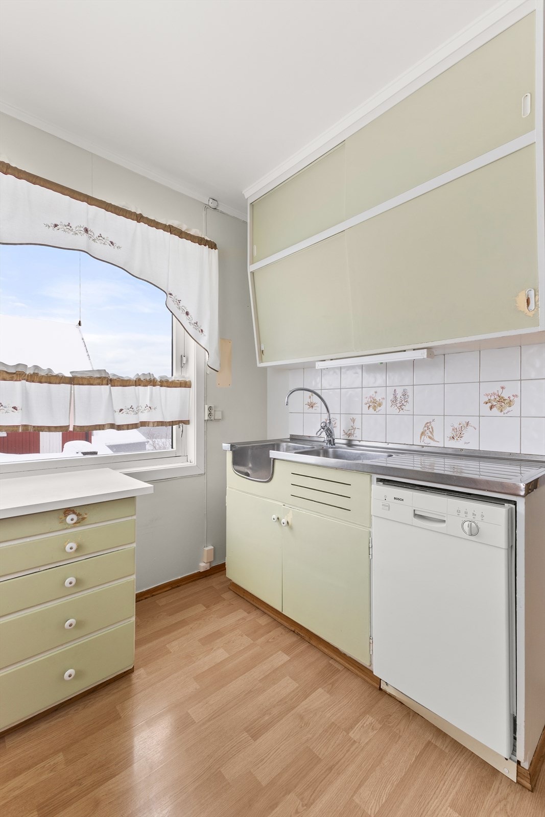 Det er oppvaskkummer og benkeplate i stål, samt benkeplate i laminat over benkeskap. Galleribilde