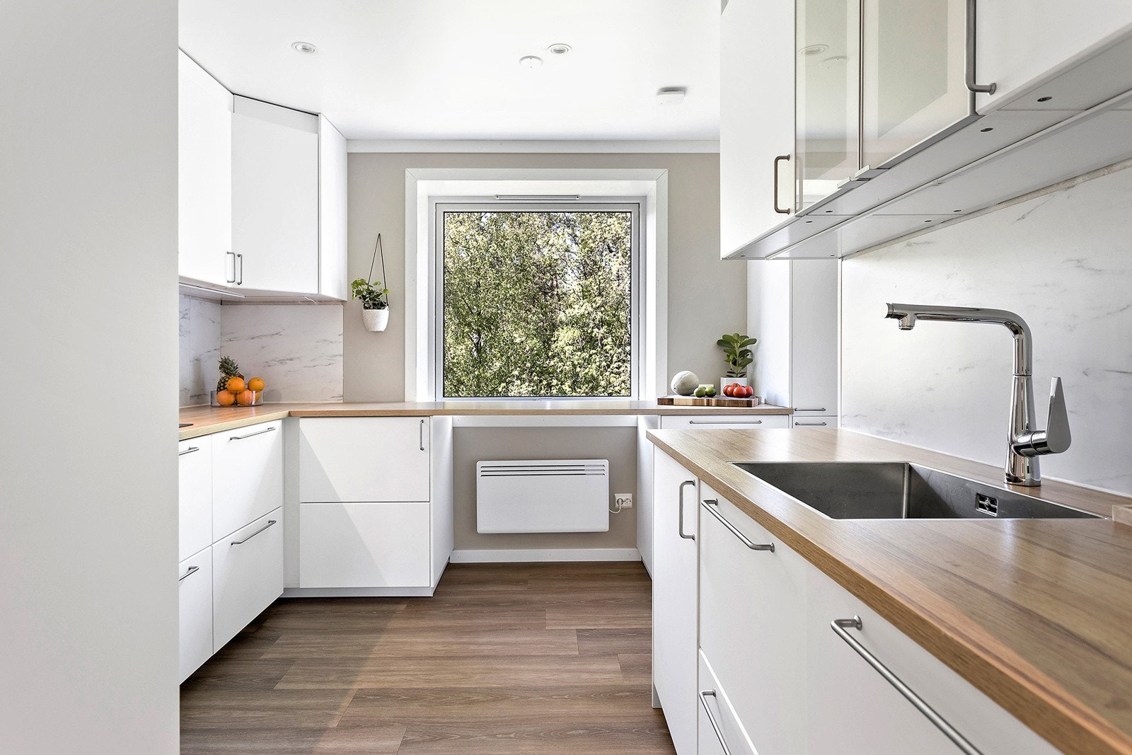 Kjøkkeninnredning med slette fabrikklakkerte fronter og laminat benkeplate. Galleribilde