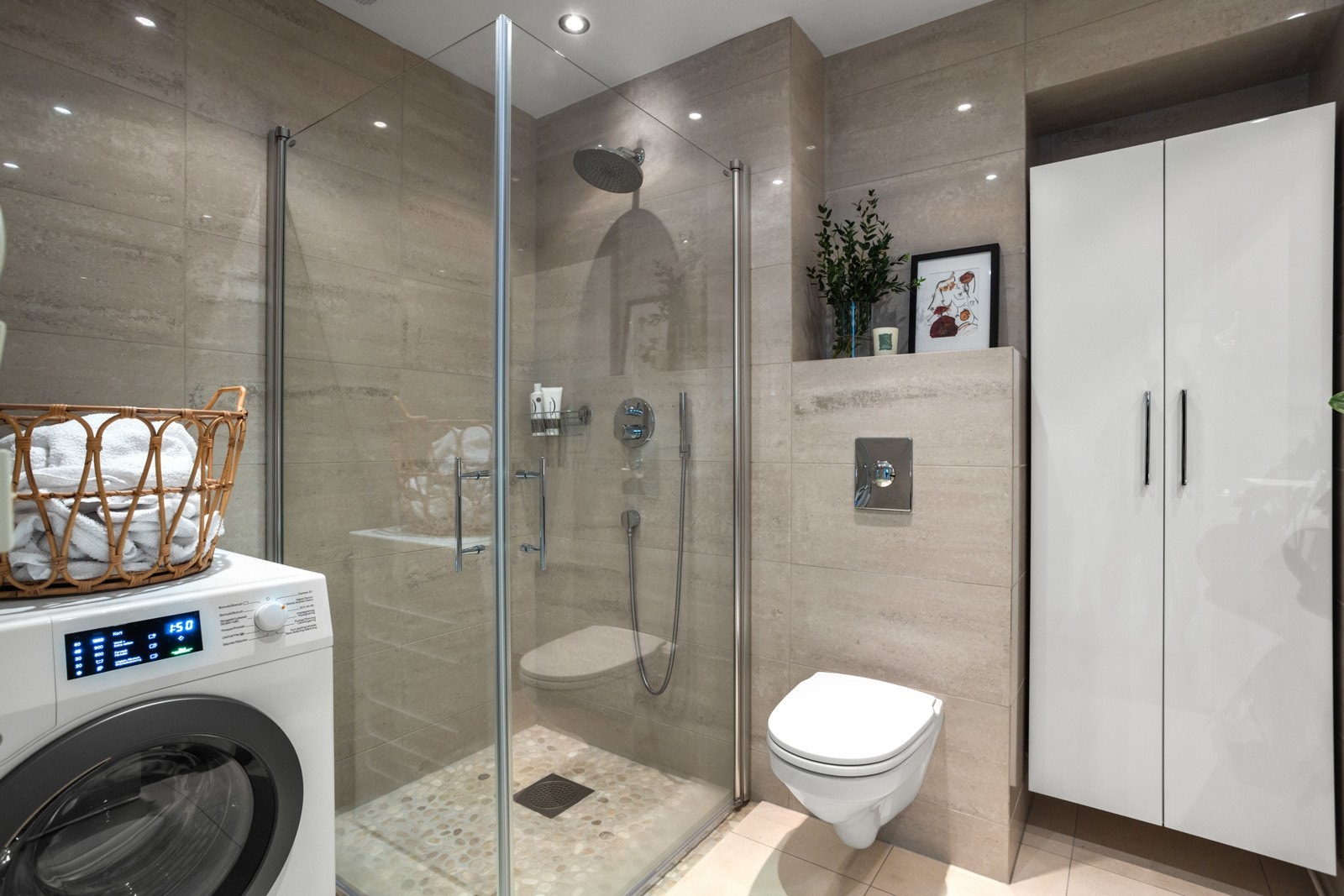 God lagringsplass på badet og opplegg for vaskemaskin. Innebygget sisterne og innebygget regnfalls- og hånddusj Galleribilde