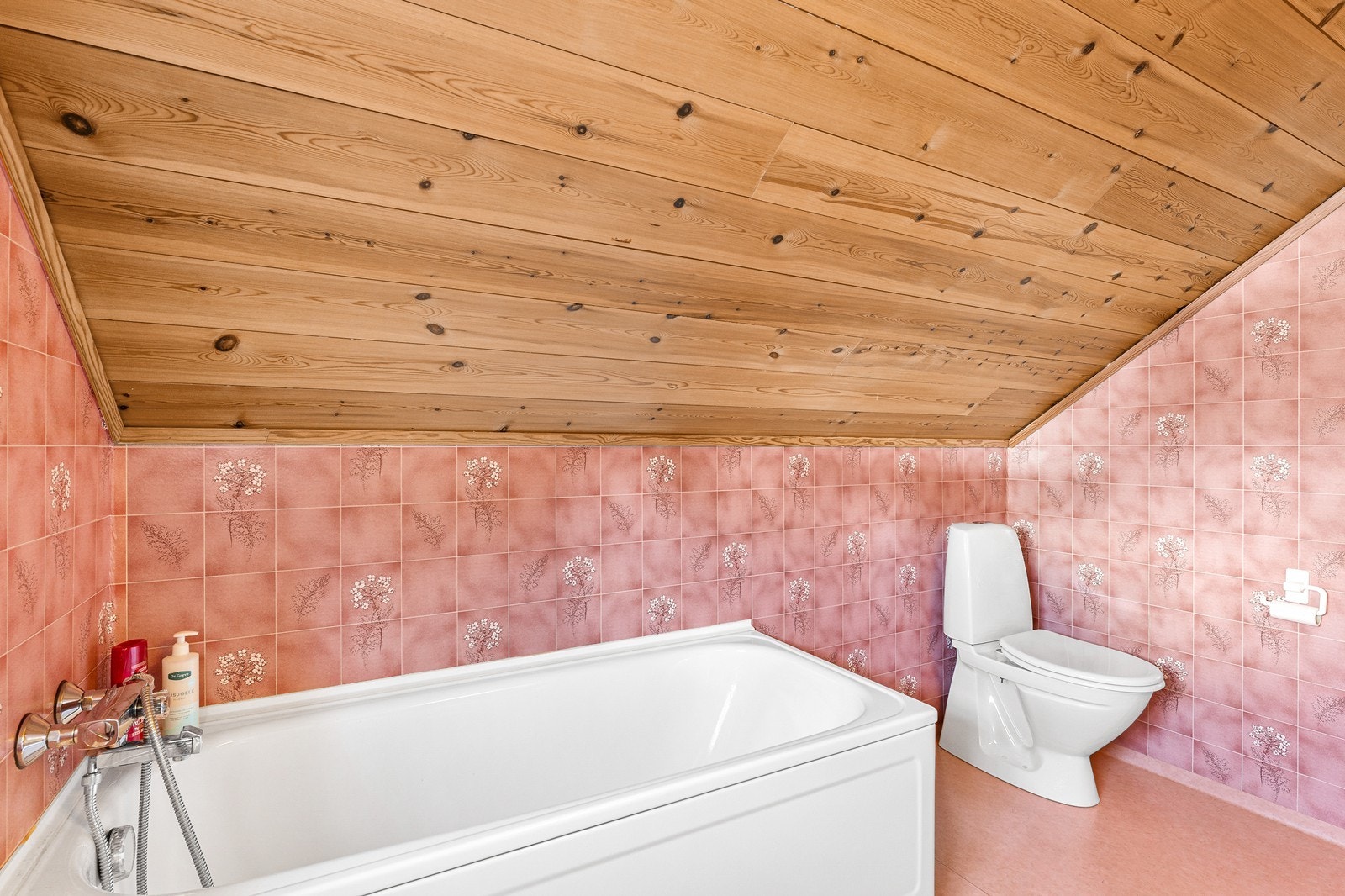 Baderomsinnredning med enkel vask, badekar og gulvstående toalett. Galleribilde