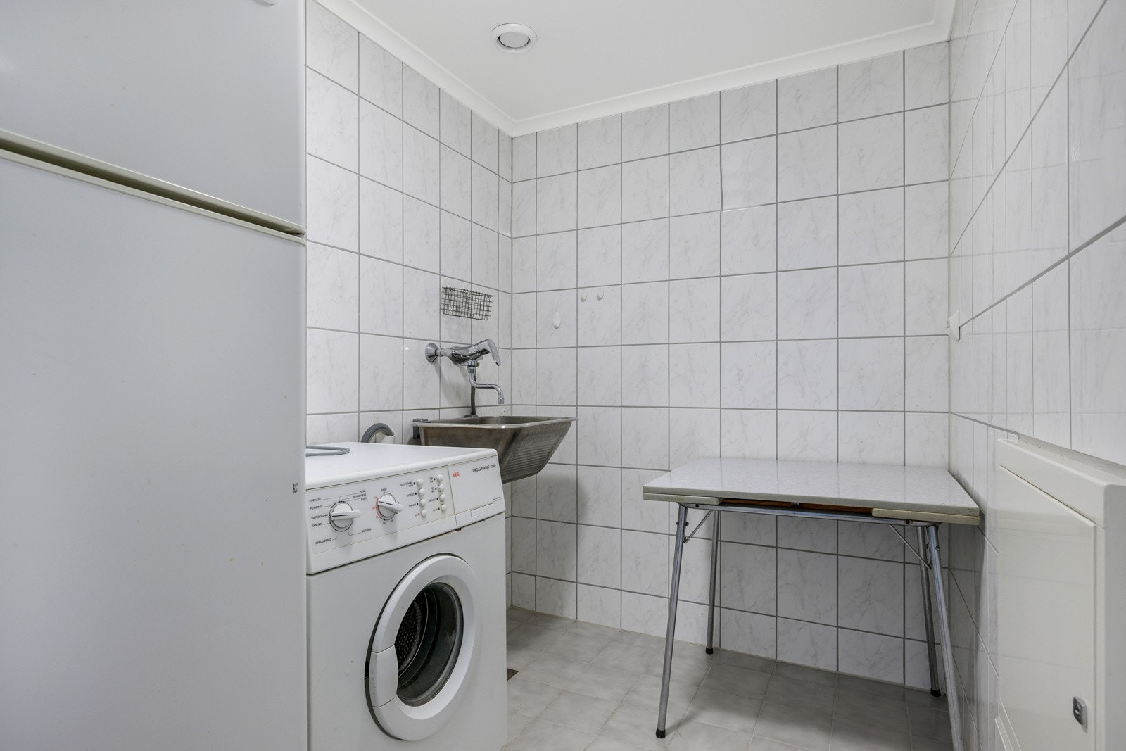 Vegg i vegg med badet finner vi et flislagt vaskerom med gulvvarme. Galleribilde