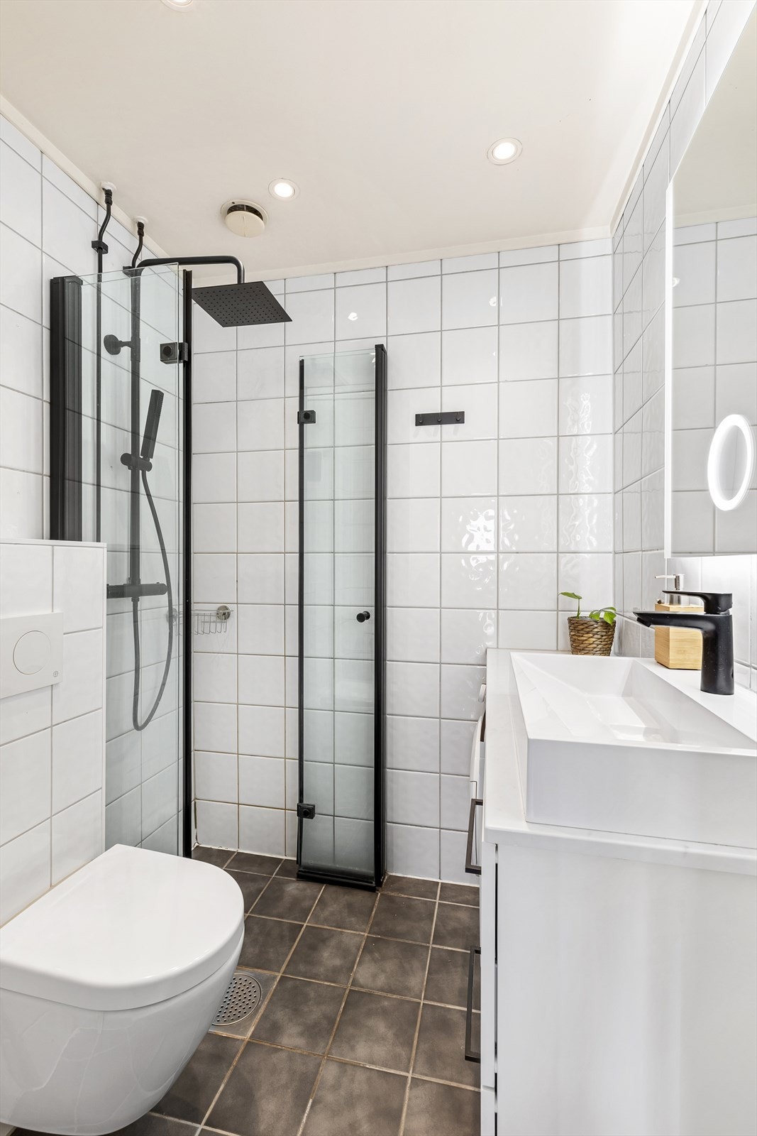 Moderne og pent flislagt bad med regnfallsdusj, vegghengt toalett, servant med underskap og speil med lys. Nylig modernisert med ny dusj, dører og nytt toalett. Galleribilde