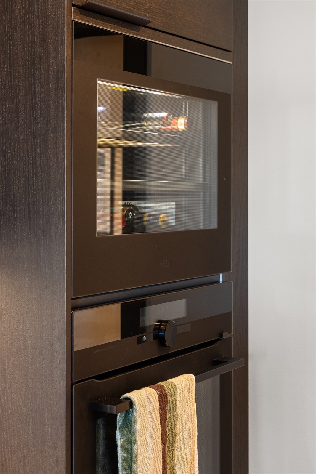 Integrerte hvitevarer består av kjøleskap med sval-del, komfyr og vinskap i høyskap, og nedfelt induksjonstopp. Vegghengt ventilator. Galleribilde