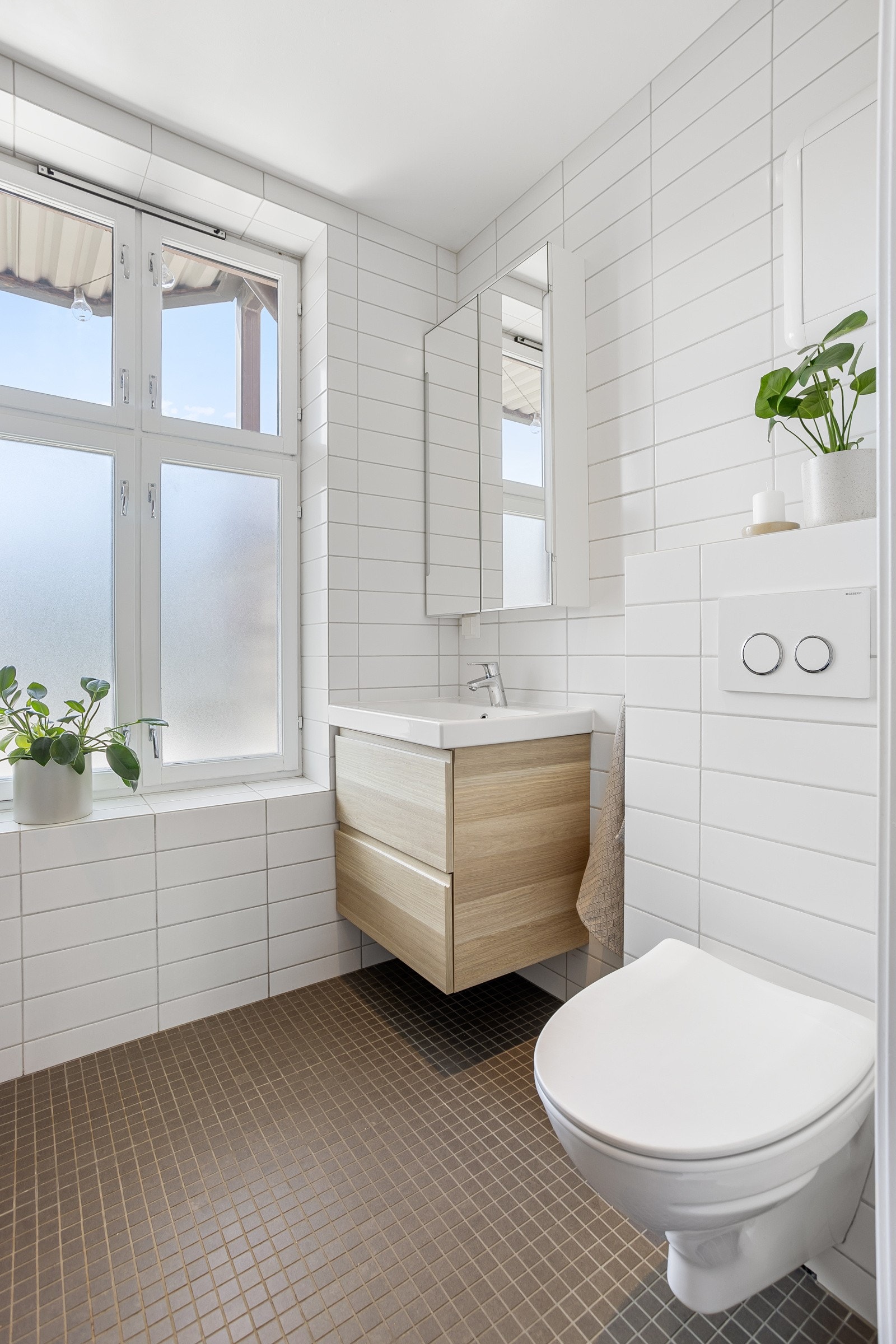 Vegghengt toalett med innebygget sisterne, opplegg for vaskemaskin og vegghengt servantskap. Galleribilde