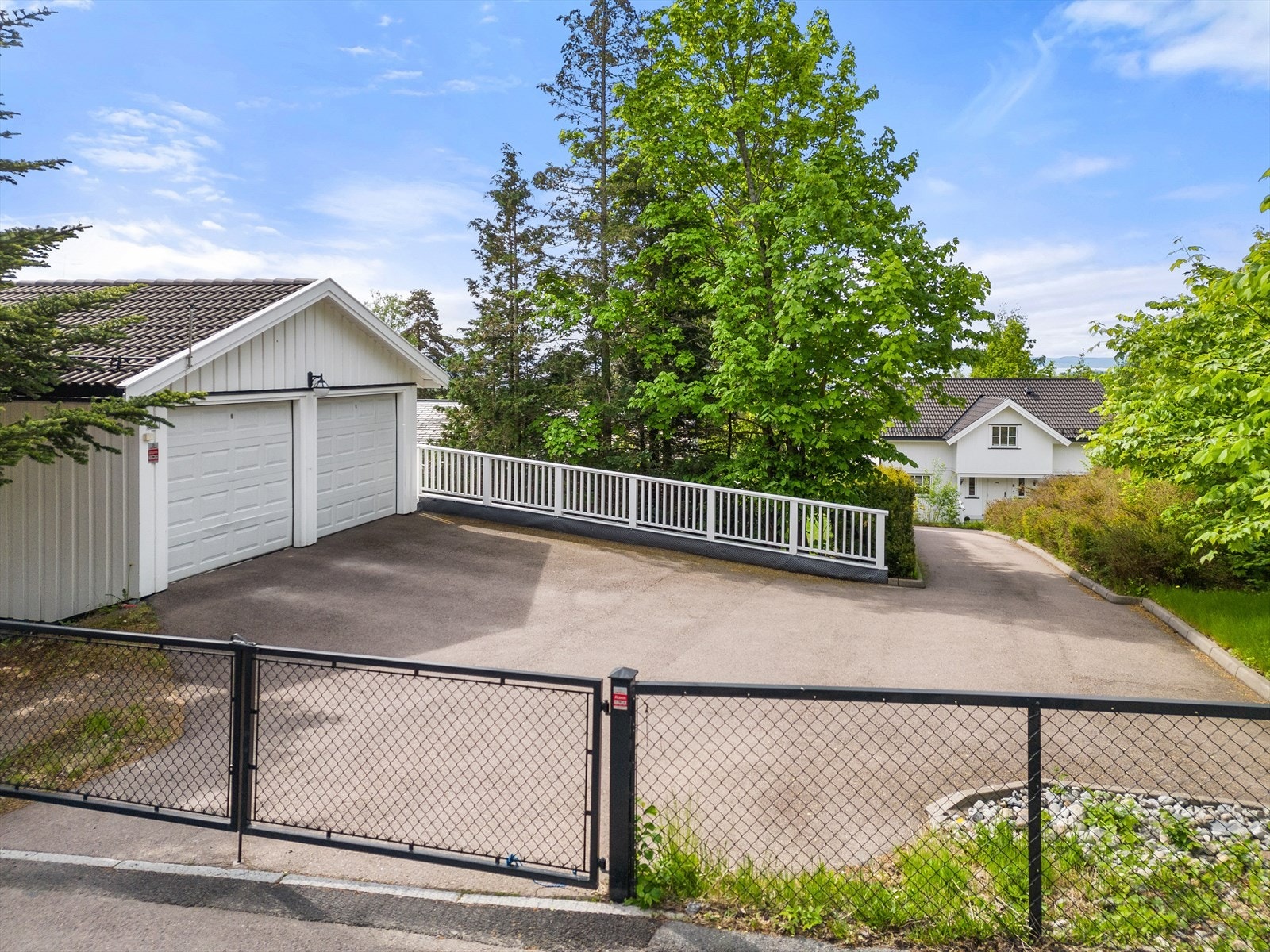 Stor dobbelgarasje (36kvm) og biloppstillingsplasser ved eiendommens innkjørsel Galleribilde