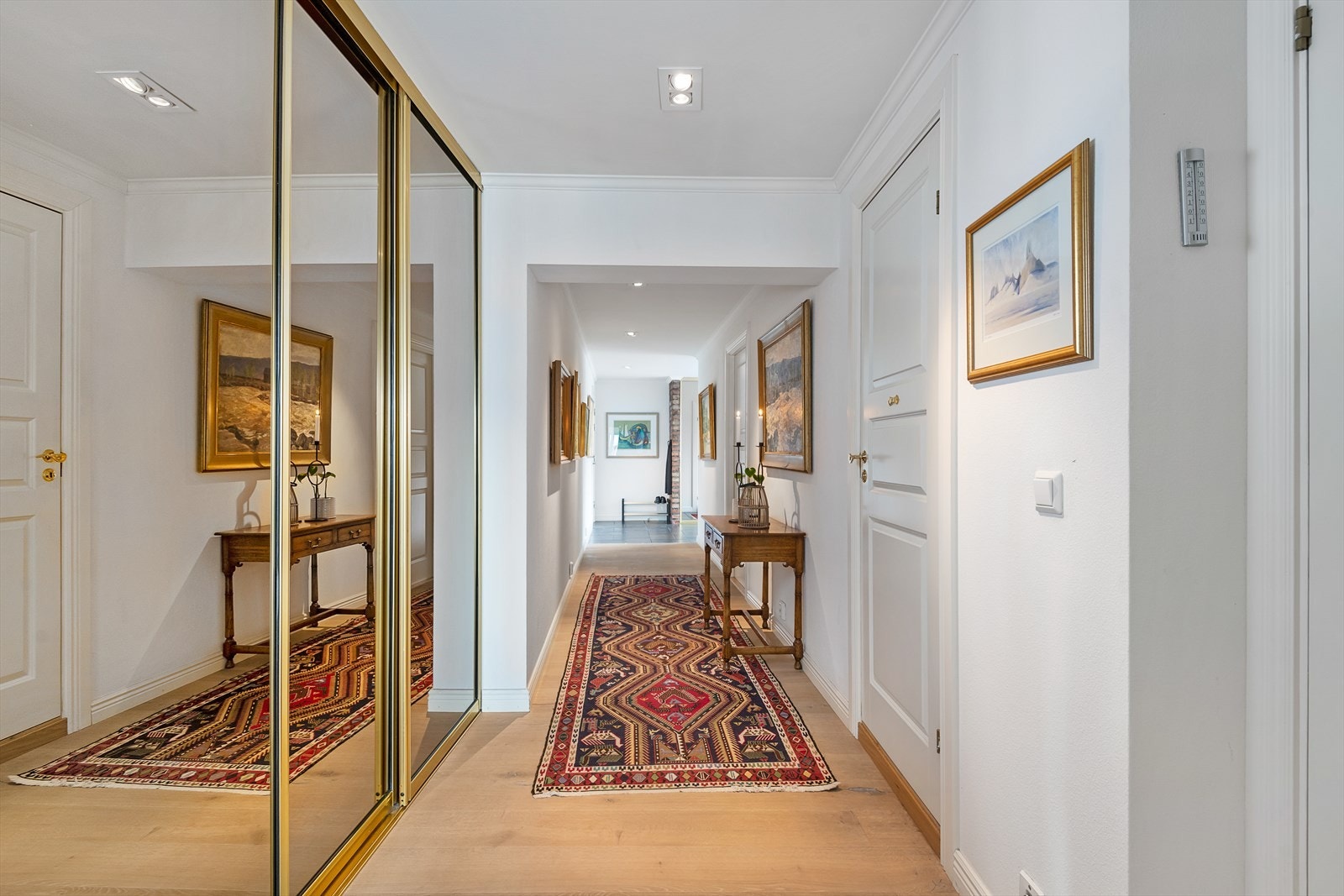 I gangen som leder videre inn i leiligheten finner vi nok en stor skyvedørsgarderobe som byr på rikelig med lagringsplass. Speilfrontene bidrar til en god romfølelese. Galleribilde