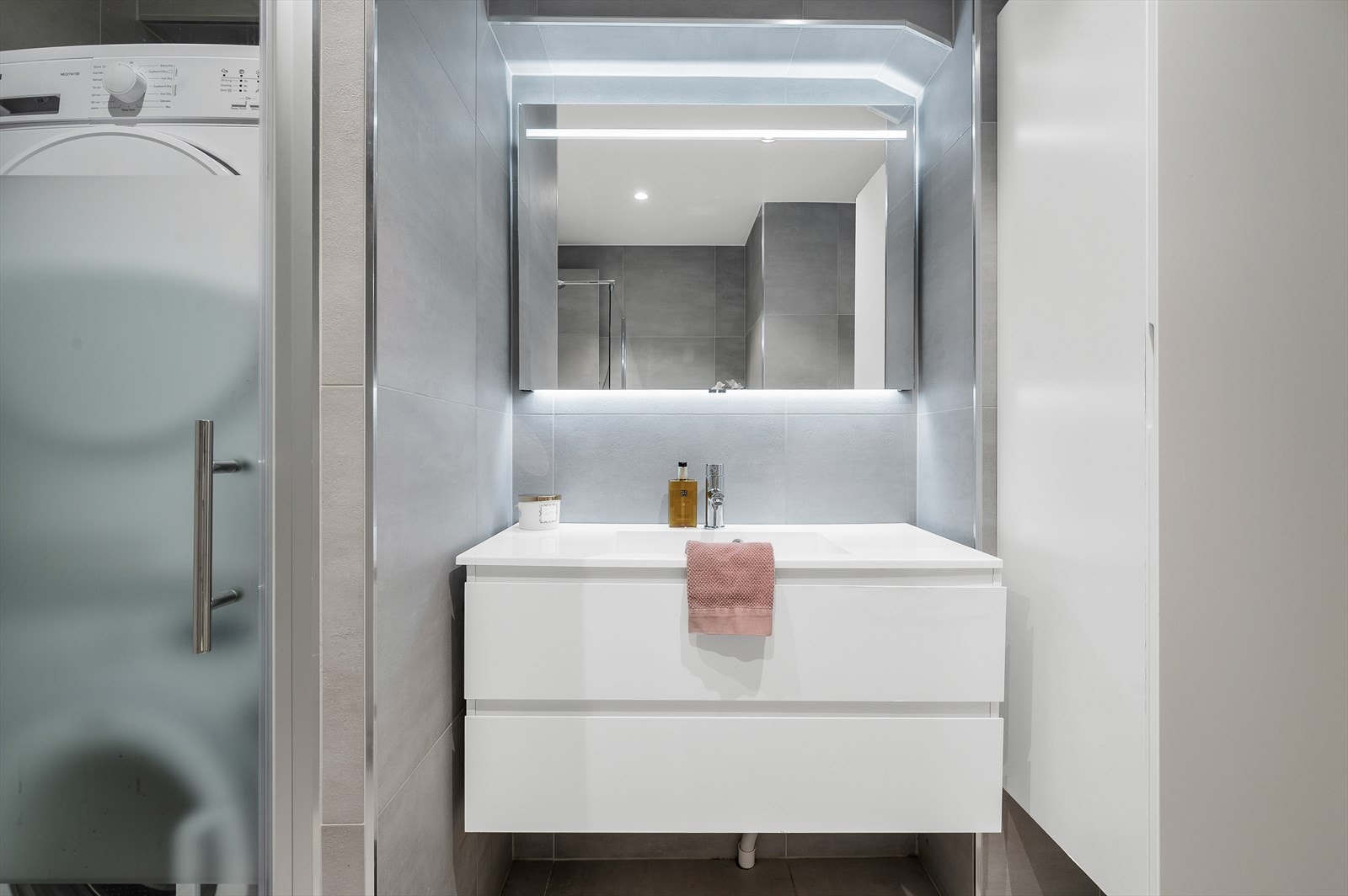 Du har også en praktisk vaskenisje, som optimaliserer plassen ved å skille vaskemaskin og tørketrommel fra resten av badet. Galleribilde