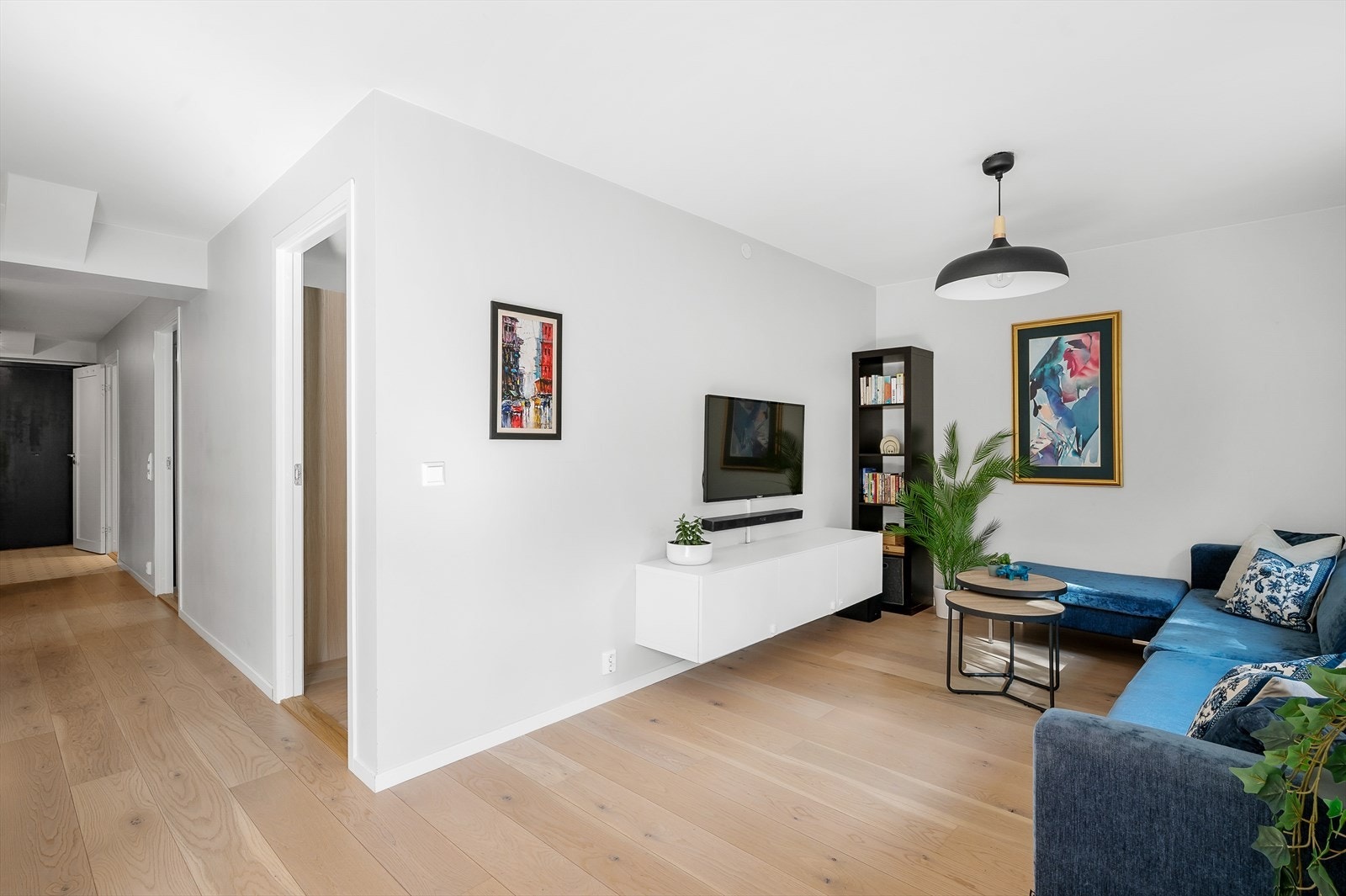 Moderne stue med lyse vegger og enstavsparkett. Galleribilde