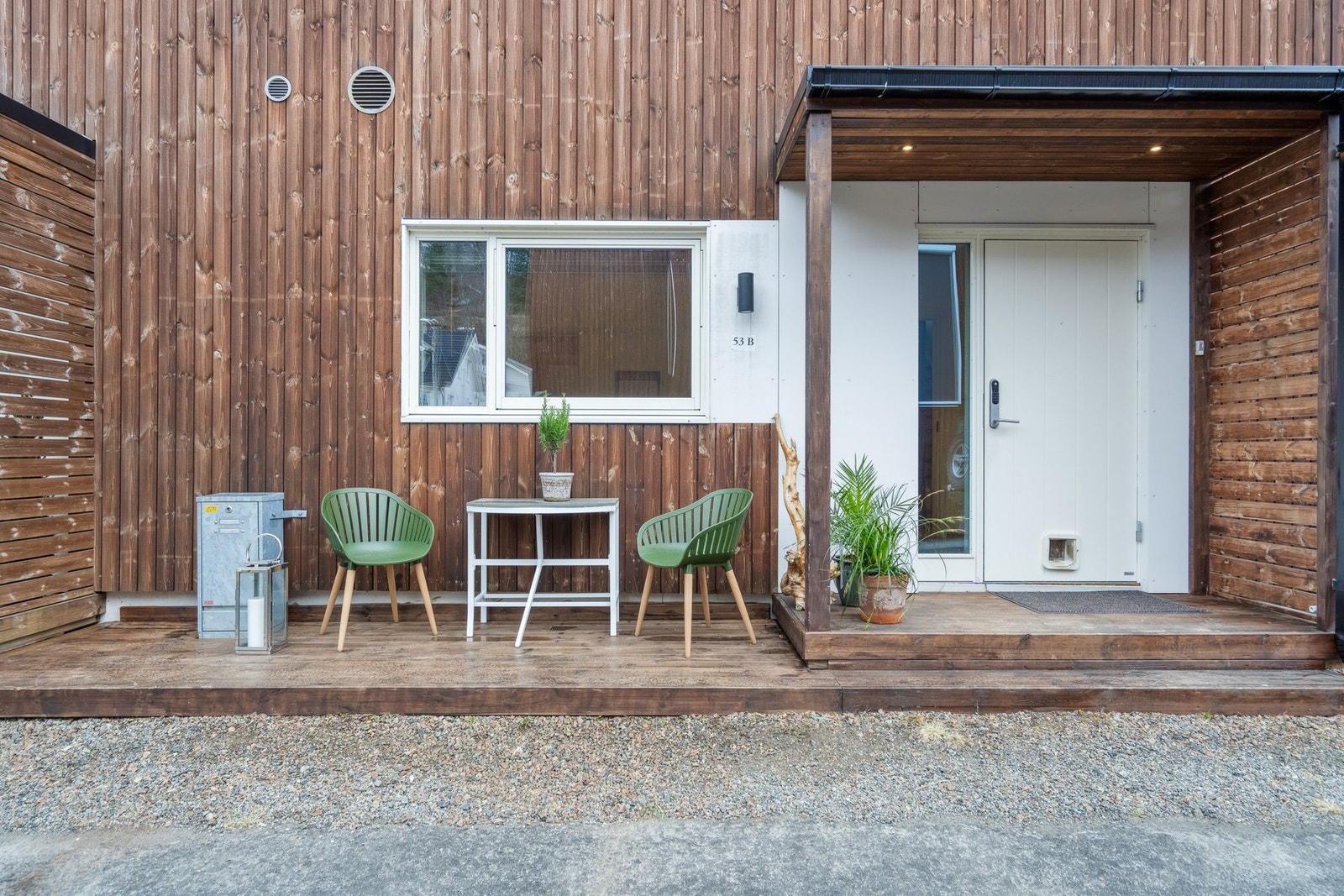 Overbygget inngangsparti og platt med kveldssol. Galleribilde