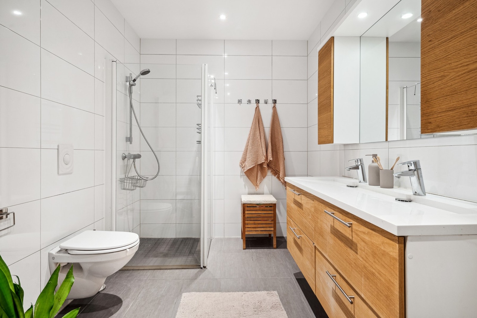 Flott flislagt bad med dusjhjørne, vegghengt toalett og dobbelservant. Galleribilde