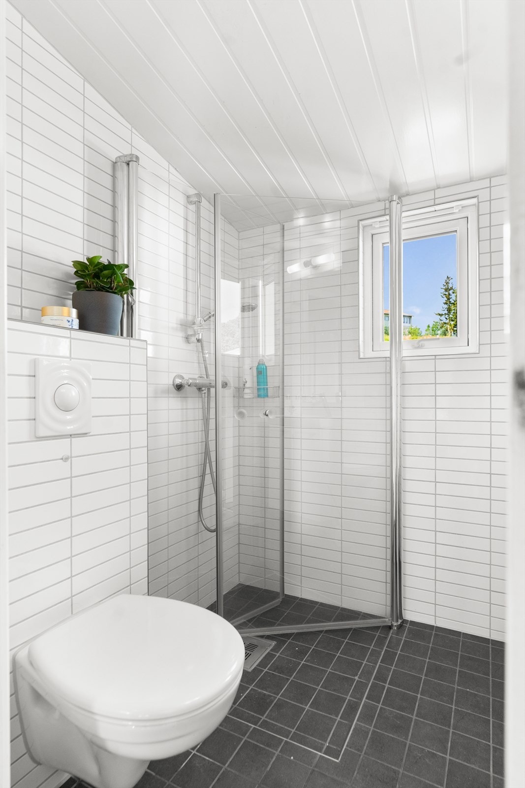 Det andre badet har innfellbare dusjdører, vegghengt toalett, skap og heldekkende servant. Galleribilde