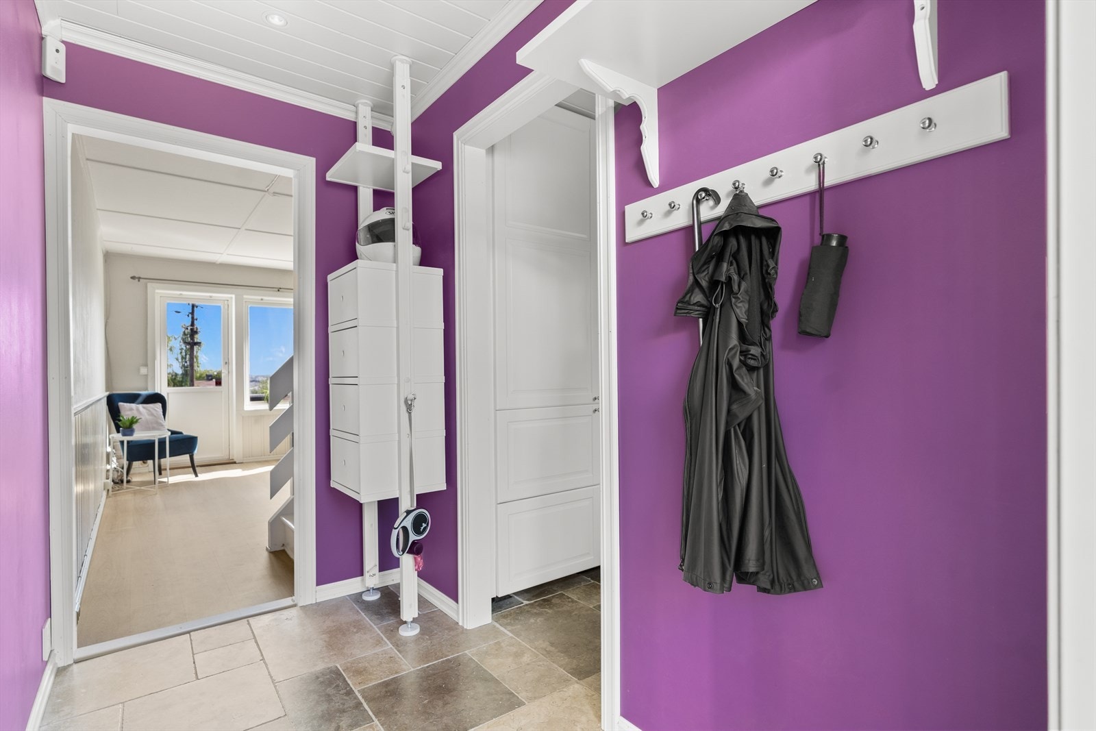 Boligen har en innbydende entré med plass til å henge fra seg yttertøy og sko. I gulvet er det stein med varmekabler - praktisk og pent. Galleribilde