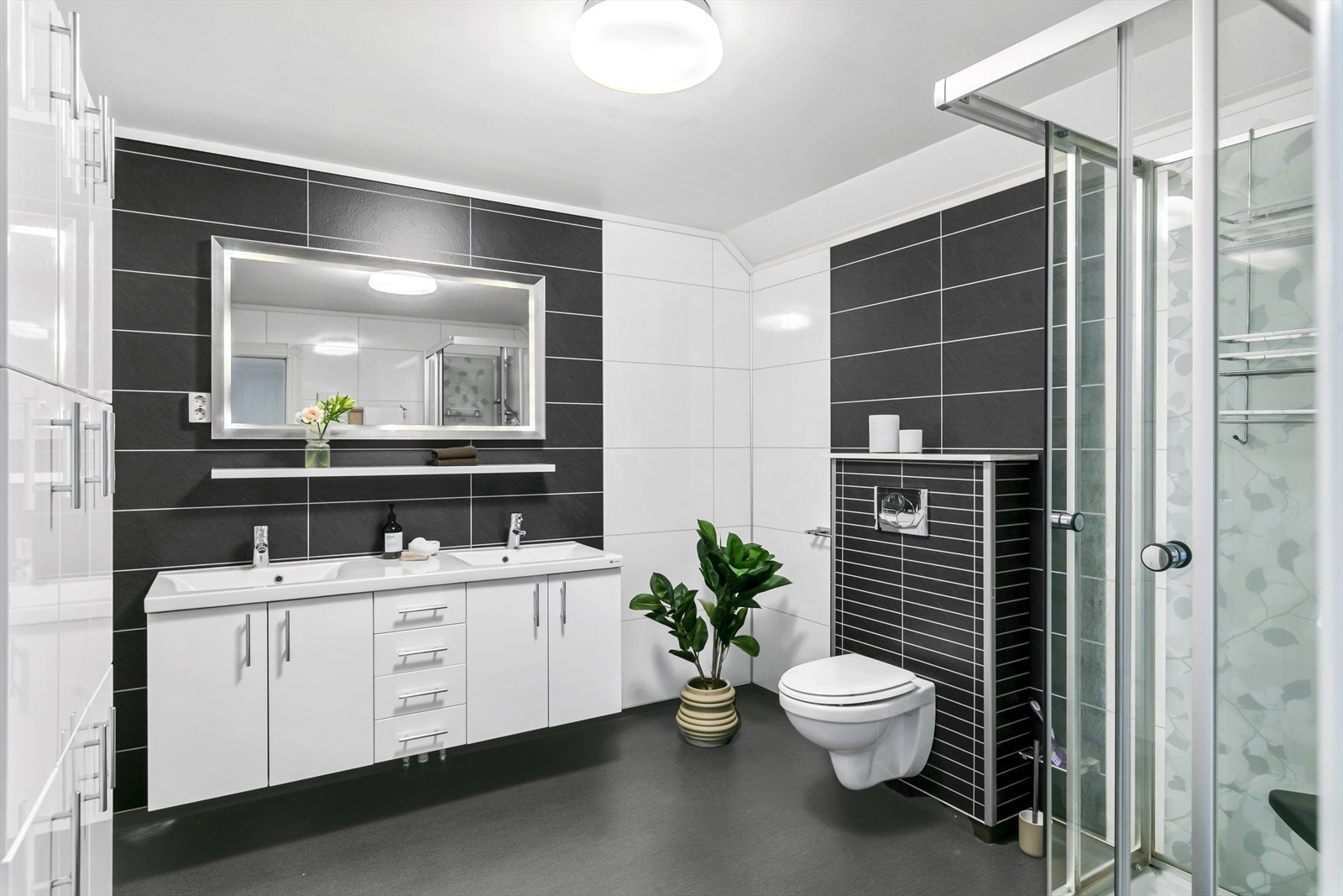 Det store badet i tredje etasje er utstyrt med dusjkabinett, toalett og innredning med vask. Galleribilde