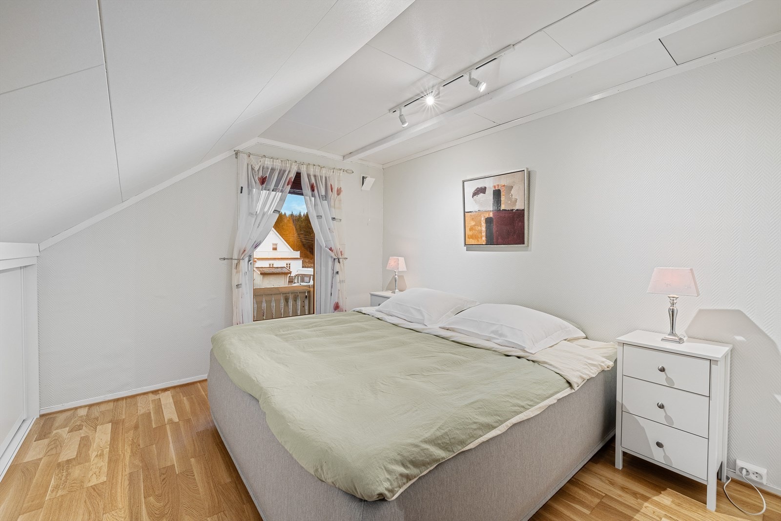 Lyst og delikat hovedsoverom med stor skyvedørsgarderobe i kneveggen. Utgang til solrik balkong. Galleribilde