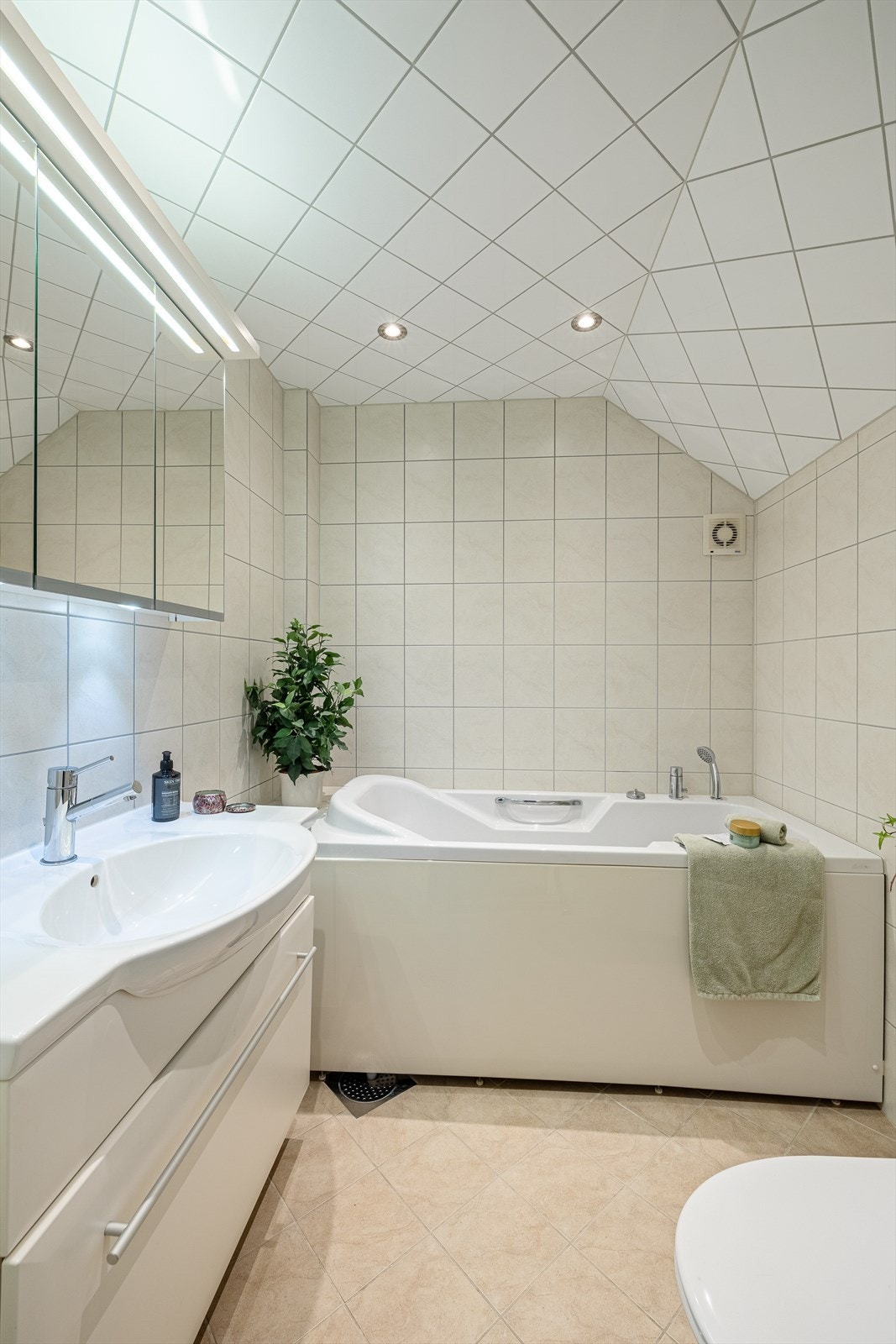 Innredet med badekar med bobler, møbel m/servant, speilskap og vegghengt klosett. Galleribilde