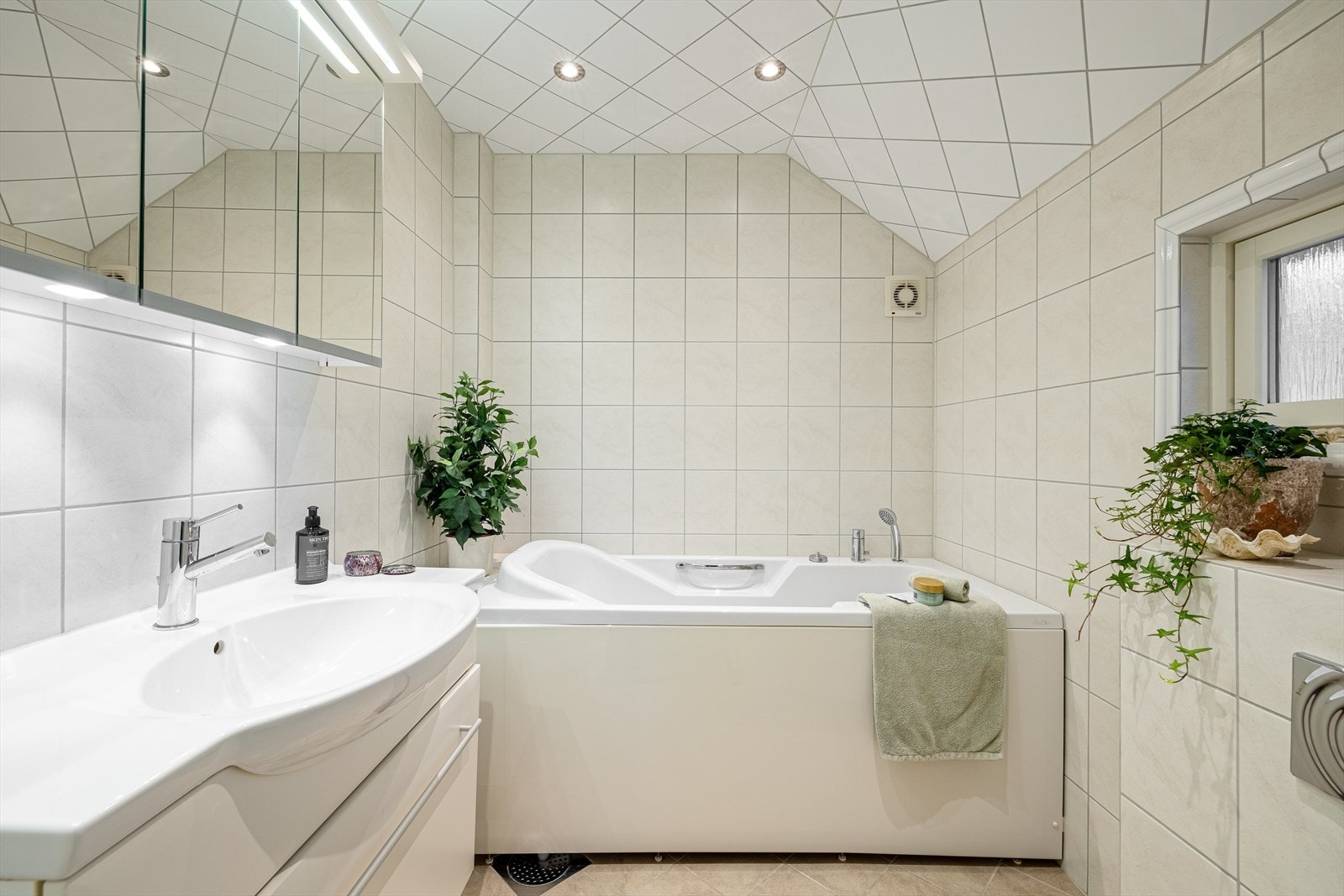 Delikat baderom med flis på gulv, vegger og i tak. Galleribilde