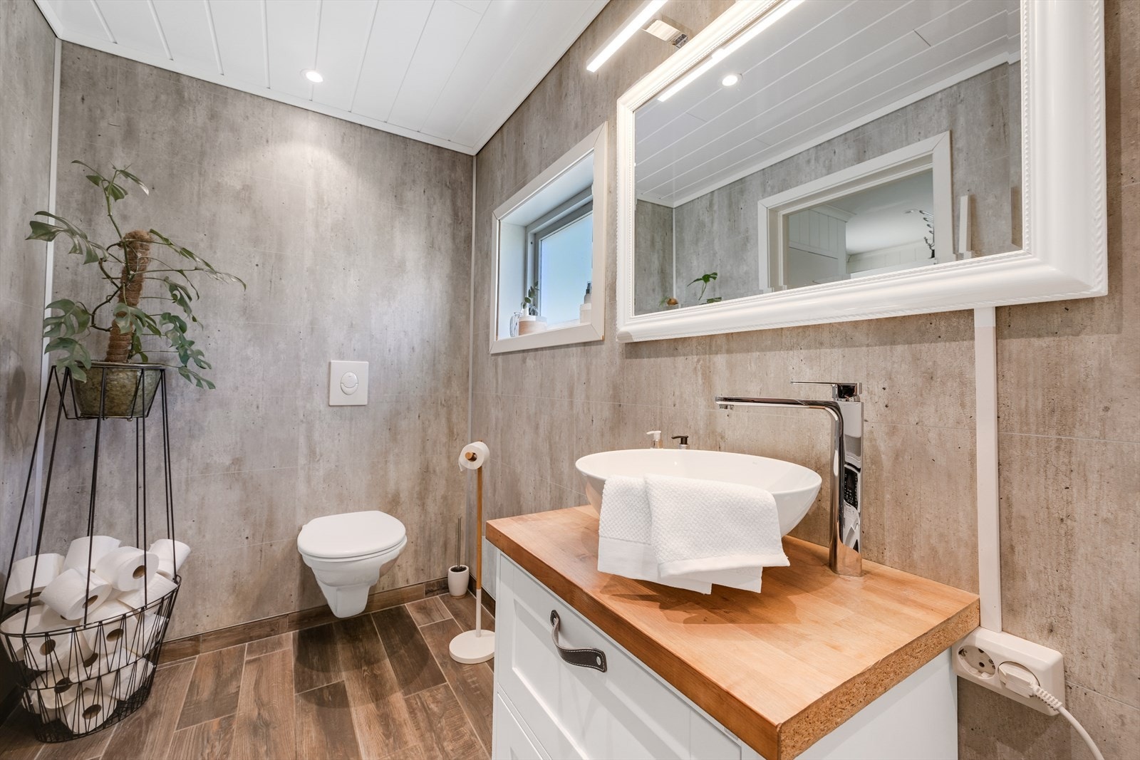 Bad/wc med dusjkabinett, servant, vegghengt toalett og opplegg for vaskemaskin. Galleribilde