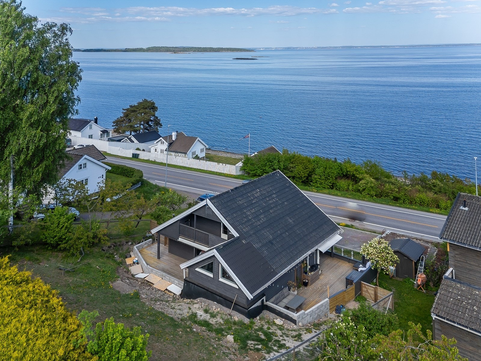 Dronefoto som viser de store uteplassene, hagen i bakkant og nærheten til sjøen. Galleribilde