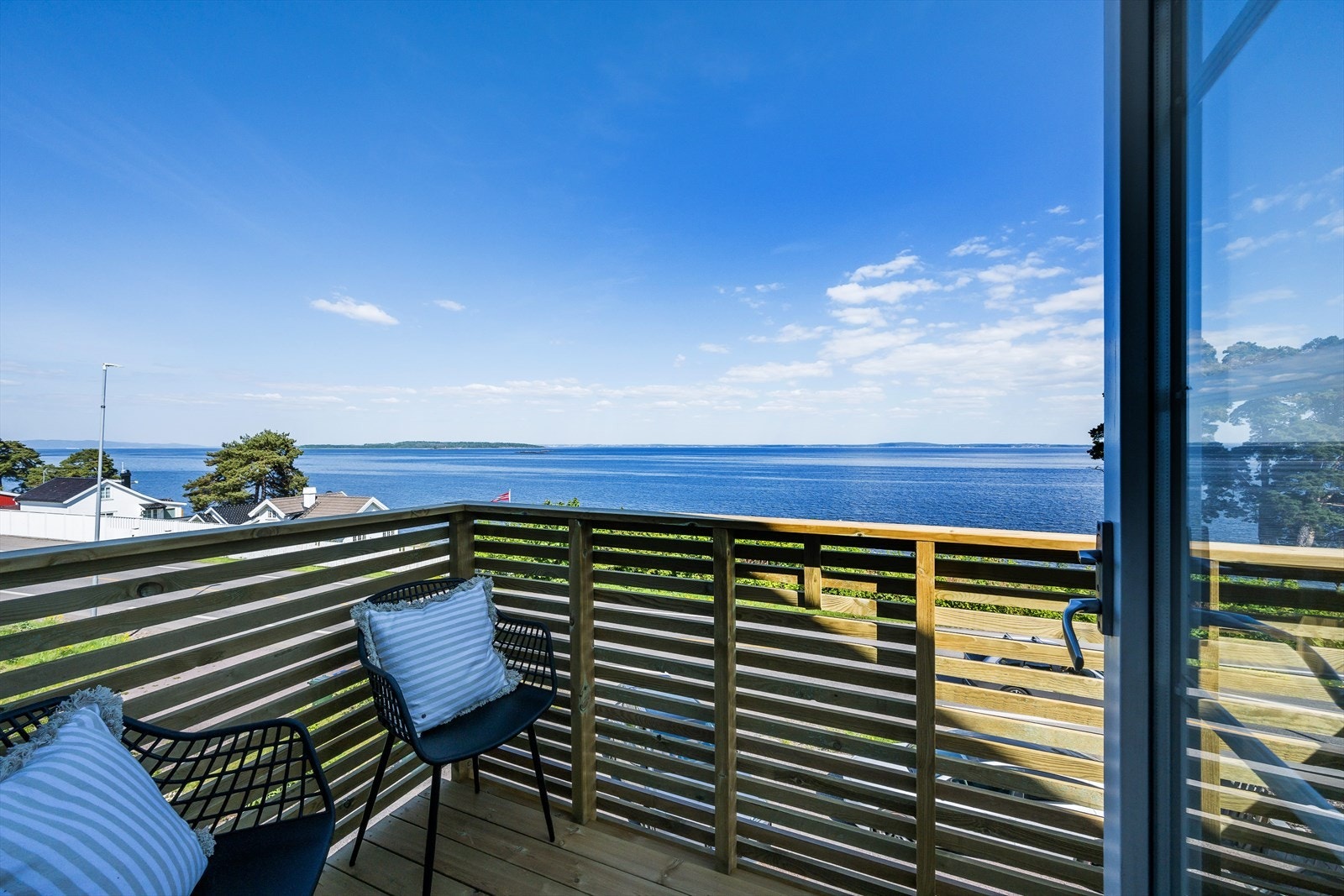 Nybygget balkong mot sjøen og formiddagssolen. Galleribilde