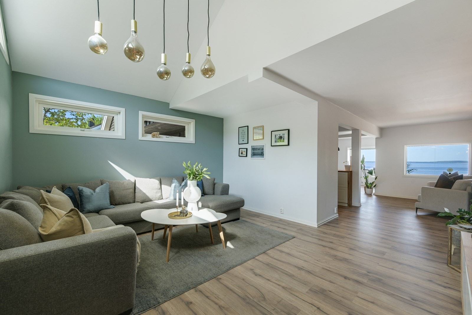 Stue med skråtak og sjøutsikt fra der hvor kamera står. Galleribilde