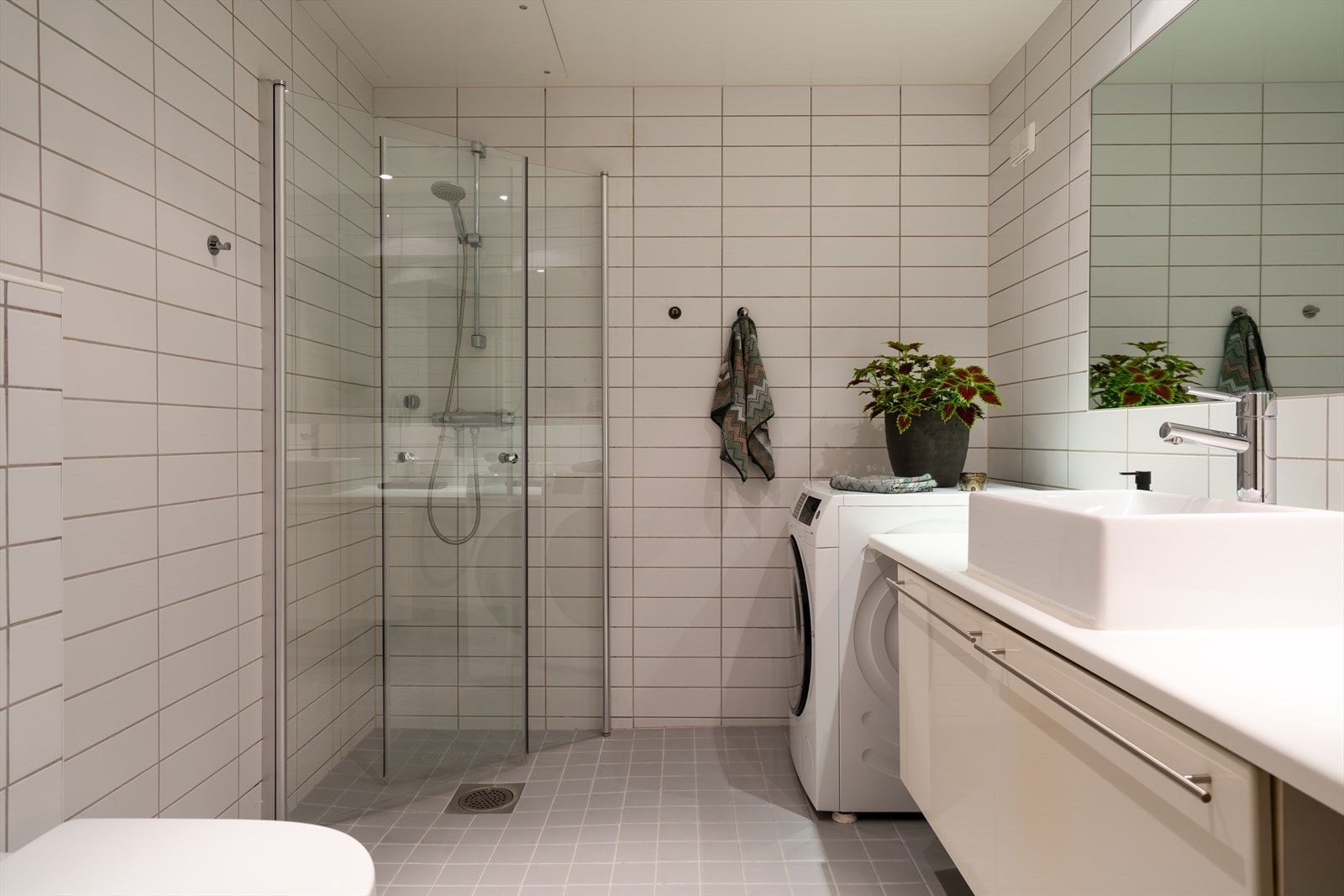 Det flislagte badet fra byggeåret 2007 har gjennomgått noen oppdateringer, inkludert bytte av dusjdører i 2021 Galleribilde