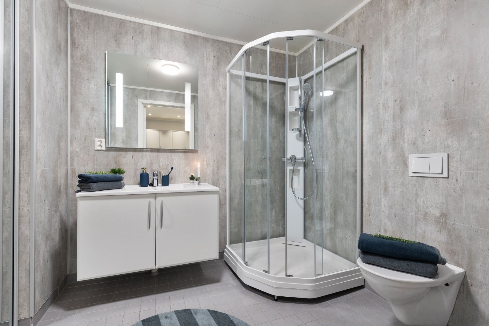 Stort bad i lekker utførelse, med skyvedører, der vaskemaskin/tørektrommel kan skjules. Veggmontert wc med trykkbetjening på vegg. Galleribilde